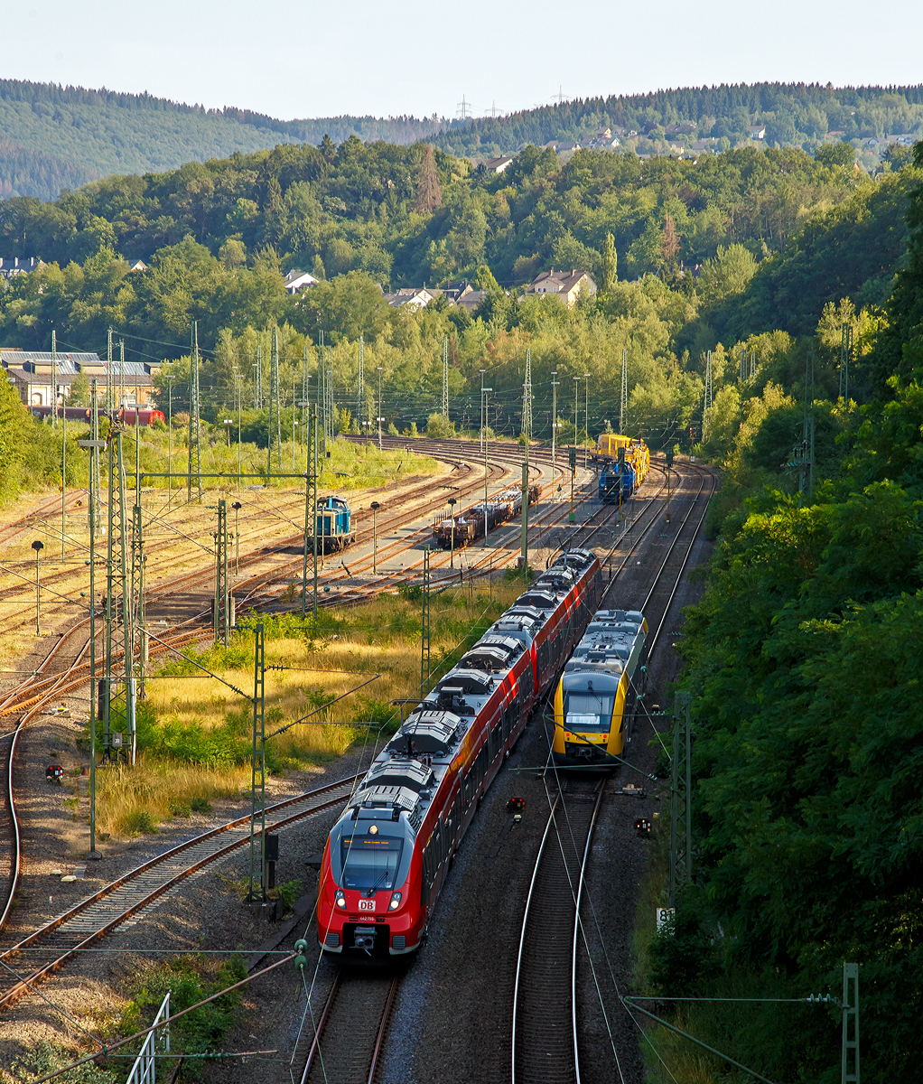 
Zwei gekuppelte Bombardier Talent 2 der DB Regio NRW verlassen am 25.07.2019, als RE 9 - Rhein Sieg Express (RSX) Siegen - Köln - Aachen, mit über 30 Minuten Verspätung Betzdorf (Sieg). Während der Alstom Coradia LINT 41 der HLB (Hessische Landesbahn) VT 257 (95 80 0648 157-5 D-HEB / 95 80 0648 657-4 D-HEB) als RB 90  Westerwald-Sieg-Bahn  (Westerburg - Altenkirchen - Au/Sieg - Siegen) pünktlich Betzdorf (Sieg) erreicht. 

Links in Rangierbahnhof (Rbf Betzdorf) ist eine V 100 abgestellt und nach Tankpause wartet im Doppelpack die V100-SP-028 (92 80 1214 018-4 D-SLG)  und die V100-SP-026 (92 80 1214 016-8 D-SLG) der SLG - Spitzke Logistik GmbH mit der Spitzke Bettungsreinigungsmaschine RM 900 S auf freies Signal zur Weiterfahrt in Richtung Köln.
