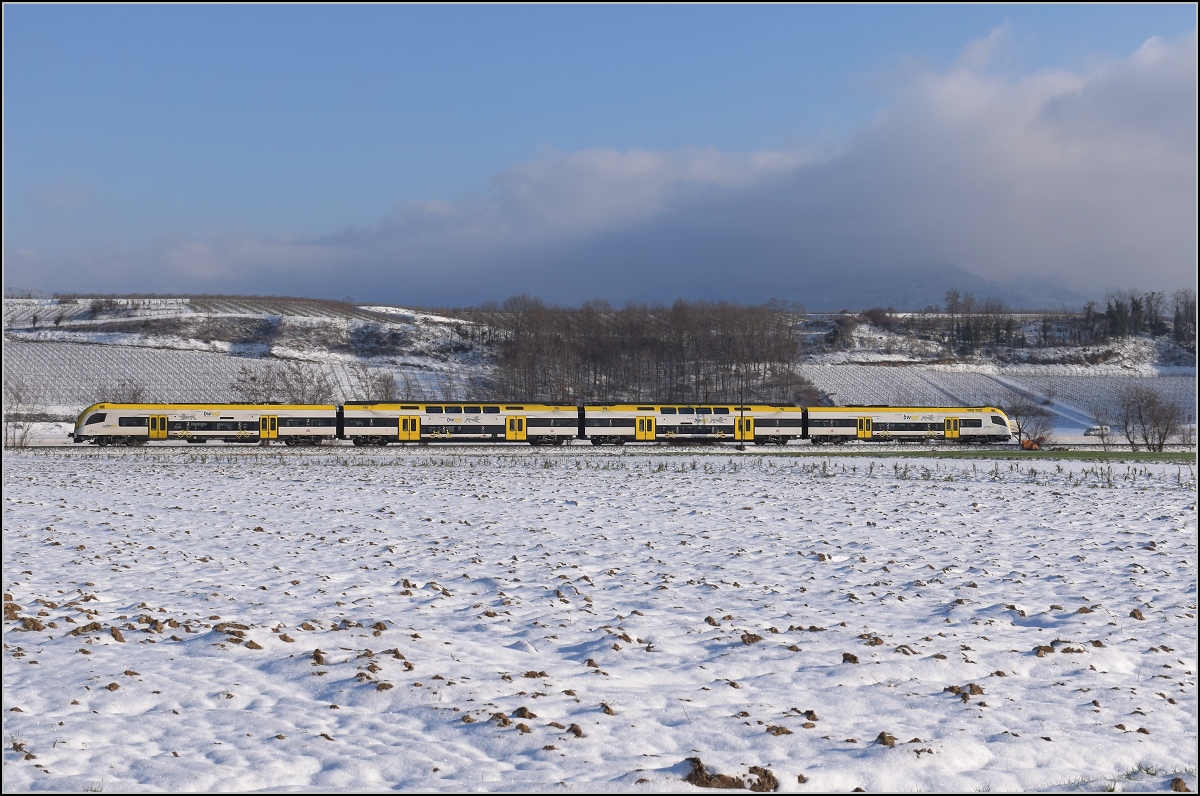 Zwischen Belchensystem und Blauendreieck. 

Ein neuer Desiro HC im bwegt-Design fährt südwärts, während sich einer der Protagonisten dieser Bilderserie langsam aus dem Nebel schält und dabei seinem Namen Blauen gerecht wird. Buggingen, Februar 2021.