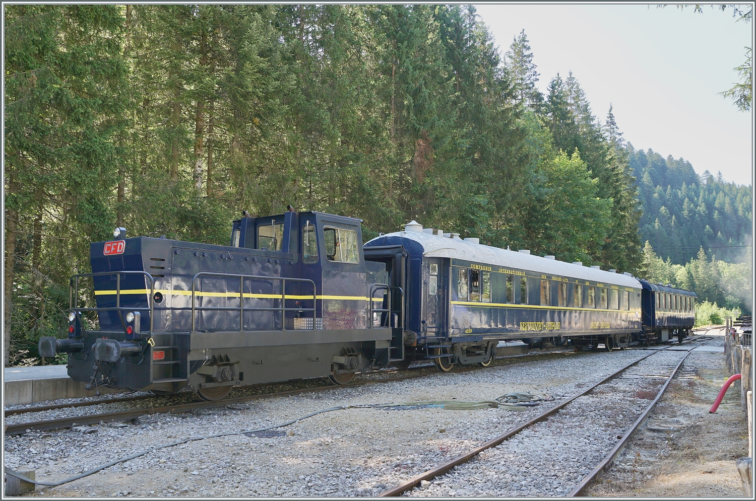 30 ANS CONI'FER /30 Jahre Coni'Fer - damit die Geleise für den starken Jubiläumsverkehr frei sind, rangiert die Tm 2/2 (ex TSOL Tm 2/2 238 291-9) die Coni'Fer  Orient Express Wagen auf eines der zahlreichen Abstellgeleise in Fontaine Ronde. Ganz so abwegig ist das Thema  Orient Express  bei der Coni'Fer nicht: Während der  Orient-Express  von Paris via Arlberg oder München Wien bzw. weiter fuhr, nutzte Frankreich nach der Eröffnung des Simplontunnels die Möglichkeit. Deutsches und Österreich-Ungarisches Gebiet mit dem Luxuszug L33/34  Simplon Express  via Pontarlier - Vallorbe - Simplon zu umgehen. Im Sommer führte der Zug unter den Namen  Oberland Simplon Express  auch Kurswagen von nun nach Interlaken, welche den Stamm in Pontarlier verliessen, bzw. dort angehängt wurden. Ab. 1907 fuhr der Zug bis Venezia und ab 1912 sogar in österreichische (!!!) Triest. Interessanter Weise war die SBB CFF mit der Traktinon der Strecken Vallorbe - Pontrlier betraut, Französiche Eisenbahner wurden in SBB Uniforem gesteckt und zum Einsatz kamen C 3/3, B 3/4 und A 3/5. Mit dem 1. Weltkrieg und 1915 mit der Eröffnung des Mont d'Or Tunnel als Abkürzung von Vallorbe nach Frasne verlor die Strecke Vallorbe Pontarlier den internationalen Verkehr, wobei die Coni'fer es geschickt versteht, den internationalen Flair wieder ansatzweise auf die Strecke zurückzuholen. 15. Juli 2023