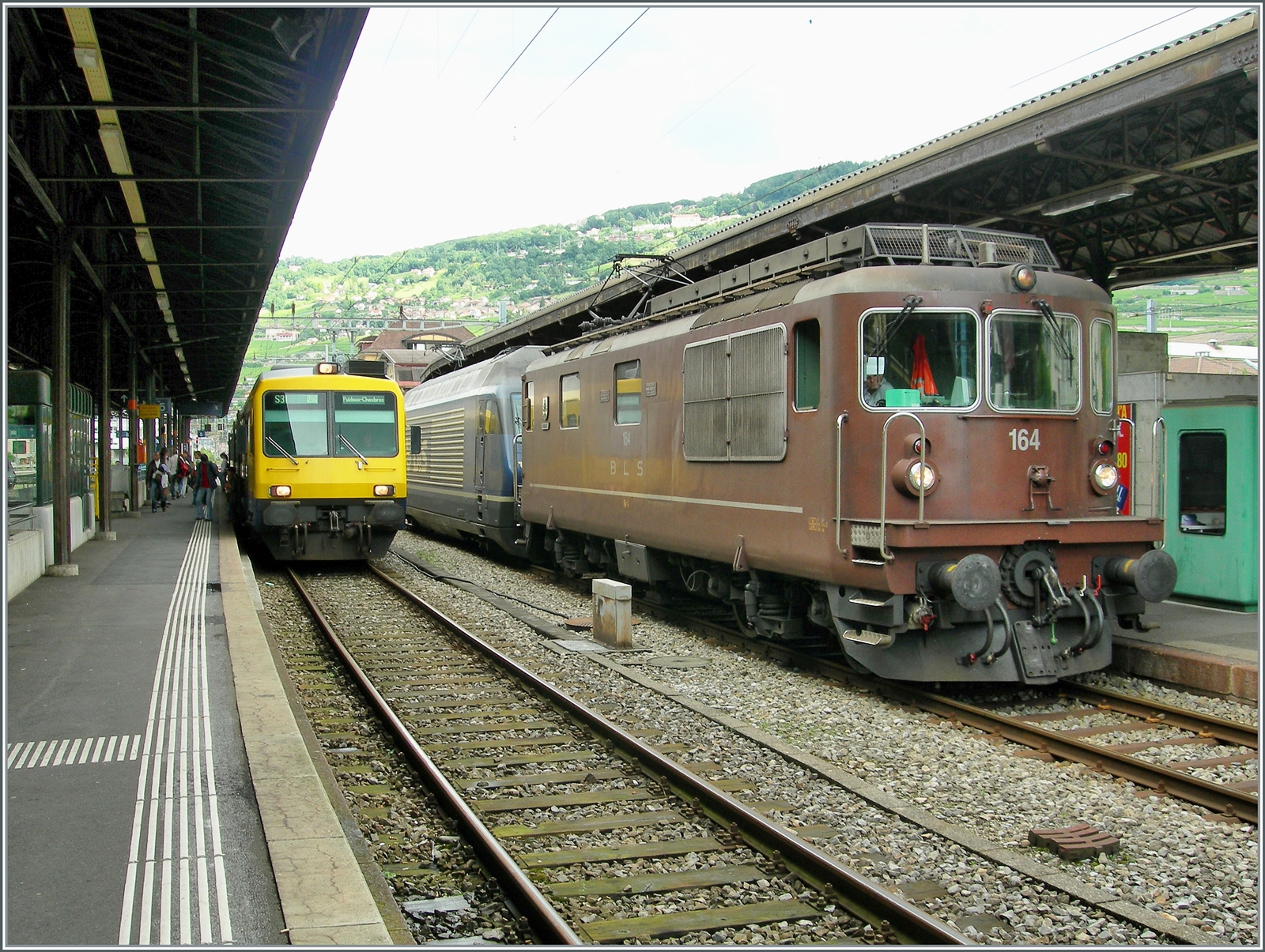 BLS Re 4/4 163 - 165 von 1967, als Ae 4/4 II 263- 265 abgeliefert; die Re 4/4 164  Lengnau  und eine BLS 465 warten in Vevey auf die Weiterfahrt; links im Bild ist der gelb/blaue  Train des Vignes zu erkennen. 

4. April 2007