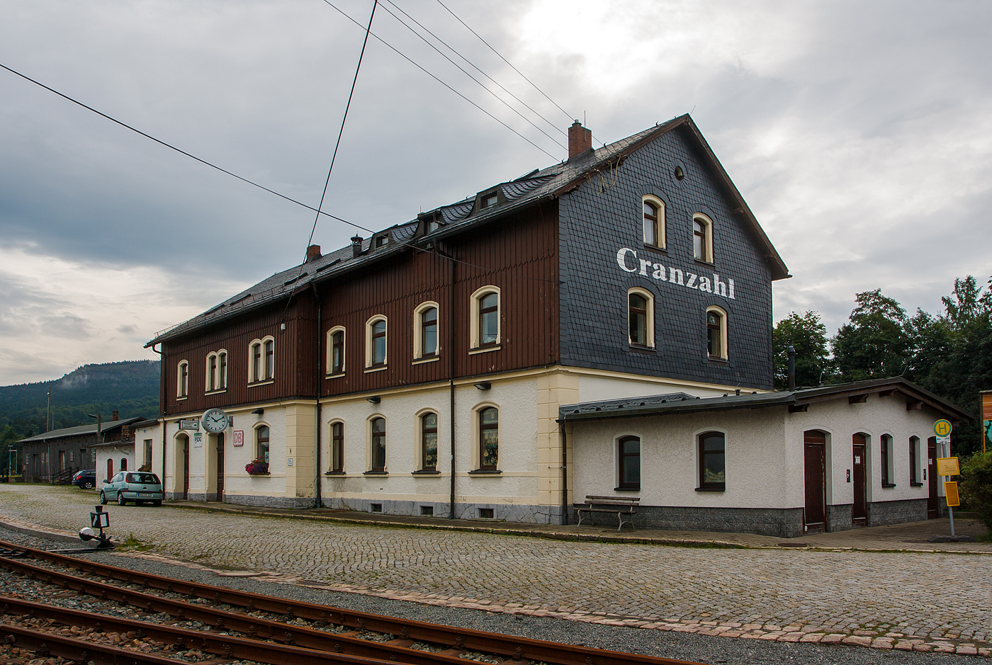 Das Empfangsgebude des Bahnhof Cranzahl am 26 August 2013.

Der Bahnhof Cranzahl ist eine Betriebsstelle der Bahnstrecke Vejprty (Weipert) - Annaberg-Buchholz unt Bf (KBS 517) und der hier anschlieenden Schmalspurbahn Cranzahl–Kurort Oberwiesenthal (SDG Fichtelbergbahn / KBS 518) auf dem Gebiet des Ortsteiles Cranzahl der Gemeinde Sehmatal im schsischen Erzgebirgskreis.

Cranzahl erhielt an der am 3. August 1872 erffneten Bahnstrecke Weipert–Annaberg einen Bahnanschluss. 1880 wurde der erste Teil des heutigen Empfangsgebudes errichtet. Mit dem Bau der Schmalspurbahn (am 19. Juli 1897 erffnet) wurde auch der Bahnhof erweitert. Das Empfangsgebude wurde ebenfalls umgebaut und erhielt seine heutige Form. An Hochbauten wurde ein einstndiges Heizhaus, eine Umladehalle und eine Betriebsmittelberladerampe neu errichtet.

Bereits bei der Projektierung war eine Rollbockgrube eingeplant, die 1899 gebaut wurde. 1906 wurde diese durch eine Rollwagengrube ersetzt. Durch den unerwartet hohen Wintersportausflugsverkehr stellte der Bahnhof ein Betriebshindernis dar. Bereits um 1900 wurde fr die Schmalspurbahn ein zweites Bahnsteiggleis gebaut, aber auch dieses konnte das Problem nicht lsen. Ab 1912 wurde daraufhin der Bahnhof grundlegend erweitert. Es wurde sdlich der Normalspuranlagen ein neuer Bahnhofsteil fr den Personenverkehr der Schmalspurbahn gebaut. Dazu musste ausreichend Bauplatz in den Berghang gesprengt werden. Seit dem Abschluss der Umbauarbeiten mssen Personenzge nicht mehr die Normalspurstrecke berqueren, auch sind Schmalspurzugkreuzungen in Cranzahl mglich. Die Gteranlagen verblieben an der bisherigen Stelle. Seitdem haben sich die Anlagen des Bahnhofs kaum verndert. Das hauptschlich als Werkstatt genutzte Heizhaus erhielt in den 1920er Jahren einen Anbau mit einer Werkstatt.

Cranzahl bekam in den Sommermonaten des Jahres 1969 ein Eilzugpaar von Berlin, das ber Zwickau fuhr, der in Annaberg-Buchholz Sd „Kopf machte“. Cranzahl erhielt im Jahre 1971 ein tgliches Eilzugpaar von Leipzig kommend und wieder zurck, dieses verkehrte noch bis zum 1. Juli 1991. Der Eilzug hielt aber nie in Annaberg-Buchholz. Im Jahre 1991 war das Ende der Eilzge nach Cranzahl eingeleitet.

Obwohl alle Lokomotiven der Schmalspurbahn immer in Oberwiesenthal stationiert sind, wurden die Dampflokomotiven lange Zeit in Cranzahl bekohlt. Der dafr vorhandene Kran wurde in den 1980er Jahren durch ein Frderband ersetzt. Seit Herbst 2023 erfolgt die Bekohlung am Bahnhof Oberwiesenthal. Grund dafr ist die Anlieferung der Kohle auf der Strae, welche bislang bis Cranzahl per Schiene erfolgte.

Die Weichen und Signale des Bahnhofs Cranzahl werden ber ein mechanisches Stellwerk der Bauart Jdel 11000 gestellt. Die Ausfahrsignale sind als Formsignale, die Einfahrsignale als Lichtsignale nach dem Hl-Signalsystem ausgefhrt, die ber Hebel gestellt werden. 

Bis 2034 soll der Bahnhof Cranzahl elektrifiziert werden. Der Grund hierfr ist der Einsatz von Akkutriebzgen, welche die starke Steigung von Annaberg-Buchholz Sd nach Cranzahl nicht schaffen wrden.
