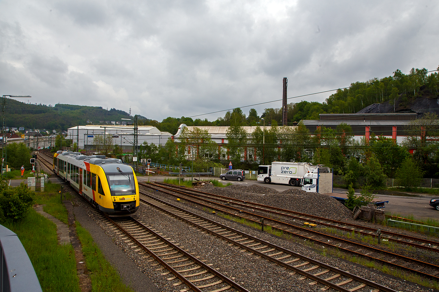 Der Dieseltriebzug VT 262 (95 80 0648 162-5 D-HEB / 95 80 0648 662-4 D-HEB) ein Alstom Coradia LINT 41 der HLB (Hessische Landesbahn), ex Vectus VT 262, erreicht am 11.05.2023, als RB 93 Rothaarbahn (Bad Berleburg - Kreuztal - Siegen Hbf - Betzdorf), bald den Bahnhof Niederschelden. 

Hier überquert er gerade den Bü 343 (km 112,183) und ist somit schon in Niederschelderhütte (PLP). Kurz dahinter verläuft die Sieg die auch Landesgrenze zwischen NRW (Nordrhein-Westfalen) und RLP (Rheinland-Pfalz) ist und die Orte Niederschelden (zu Siegen) und Niederschelderhütte (zu Mudersbach) trennt. So müsste der Bahnhof Niederschelden (heißt bei der DB so), müsste aber eigentlich Niederschelderhütte heißen, wo er liegt.

Im Hintergrund noch erhaltene Hallen der ehemaligen Charlottenhütte, sie war eine bedeutende Eisenhütte mit zwei koksbetriebenen Hochöfen.
