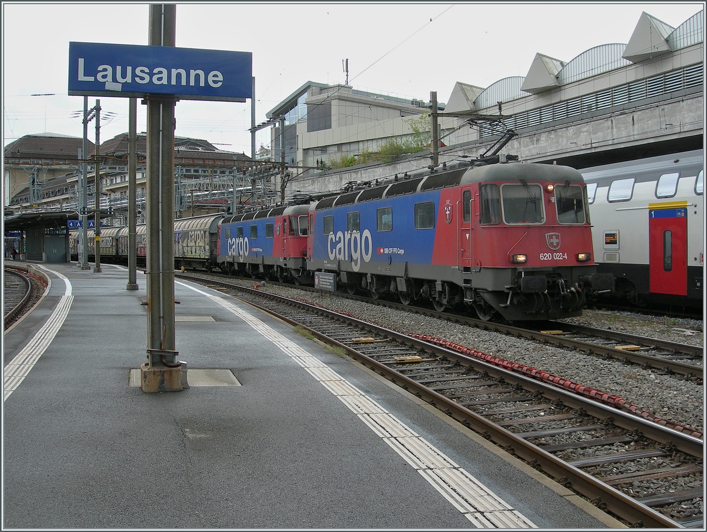 Der EWLV Güterzug Zug von Lausanne (Triage) nach Zürich (RBL) via Brig und Kandersteg ist  mit den beiden Re 6/6 11622 (Re 620 022-4)  Suhr  an der Spitze und dahinter mit der Re 6/6 111634-9 (Re 620 034-9)  Aarburg Oftringen  unterwegs und wartet in Lausanne auf die Blockdistanz zum vorausfahrenden IR90.

22. Mai 2025