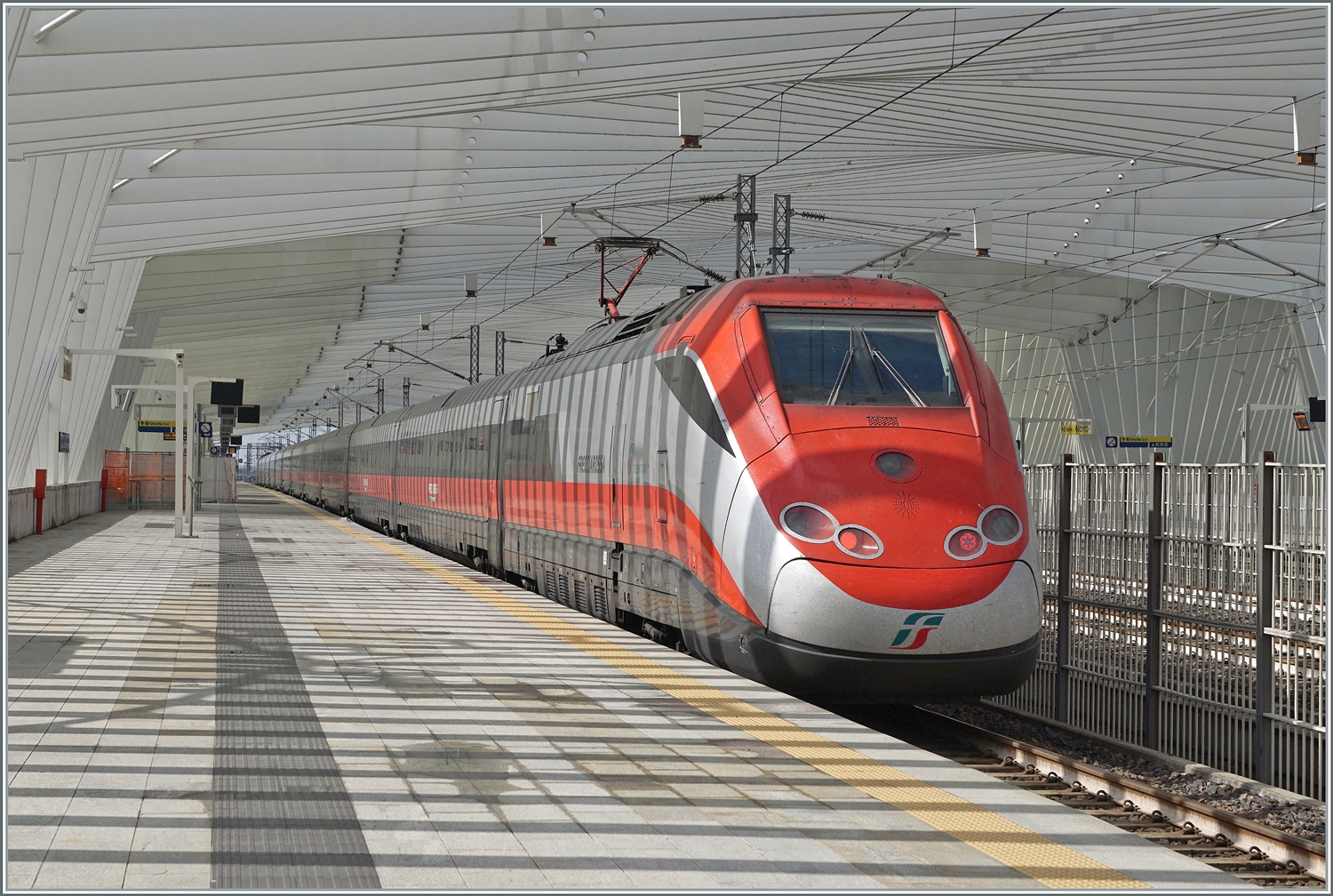 Der FS Trenitalia ETR 500 044 macht auf seiner Fahrt nach Milano einen kurzen Halt in Reggio Emilia AV. Der formschöne Bahnhof wurde vom bekannten Architekt Santiago Calatrava. 

14. März 2023