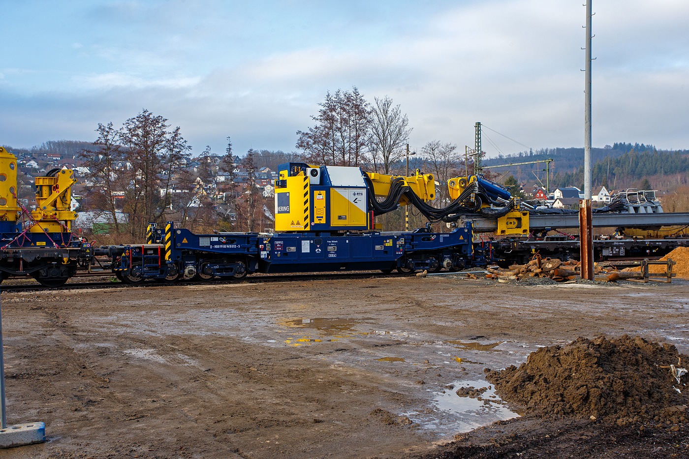 Der Gleisgründungszug der HERING Bahnbau GmbH (Burbach-Holzhausen) ist am 05 Februar 2026 auf den WEBA-Gleisen in Scheuerfeld/Sieg abgestellt. Hier das 8-achsigen gleisgebundenen Trägergerät (Baujahr 2023 durch TECHNE KIROW GmbH in Leipzig unter Fabriknummer MT 2020 171031), D-HGUI 99 80 9410 012-5, Gewicht 108.000 kg, LüP 15.000 mm.

Die Höchstgeschwindigkeit beträgt 100 km/h geschleppt, bei Eigenfahrt 5 km/h. 