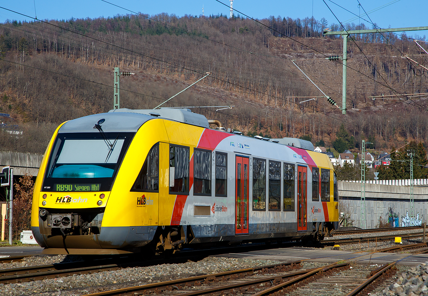 Der VT 203 ABp (95 80 0640 103-7 D-HEB), ein Alstom Coradia LINT 27 der HLB, ex vectus VT 203, verlsst am 14.02.2023, als RB 90  Westerwald-Sieg-Bahn   (Limburg/Lahn - Westerburg – Altenkirchen - Au/Sieg - Siegen), Niederschelden (eigentlich Niederschelderhtte) und fhrt weiter in Richtung Siegen.

Der Alstom Coradia LINT 27 wurde 2004 von der ALSTOM Transport Deutschland GmbH (vormals LHB - Linke-Hofmann-Busch GmbH) in Salzgitter-Watenstedt unter der Fabriknummer 1187-003 gebaut und an die vectus Verkehrsgesellschaft mbH, mit dem Fahrplanwechsel am 14.12.2014 wurden alle Fahrzeuge der vectus nun Eigentum der HLB