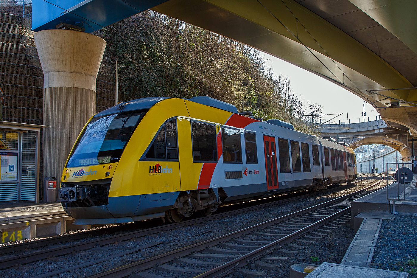 Der VT 260 (95 80 0648 160-9 D-HEB / 95 80 0648 660-8 D-HEB), ein Alstom Coradia LINT 41 der HLB (Hessische Landesbahn), als RB 90   Westerwald-Sieg-Bahn   (Limburg/Lahn – Altenkirchen – Au/Sieg - Betzdorf - Siegen - Kreuztal), am 24.03.2021 beim Halt am Hp Niederschelden Nord.

Der Haltepunkt Niederschelden Nord liegt unter der Hochstraße HTS (der B 62 neu). Danach folgt direkt der Bü 111,7 und dann die Siegbrücke.
