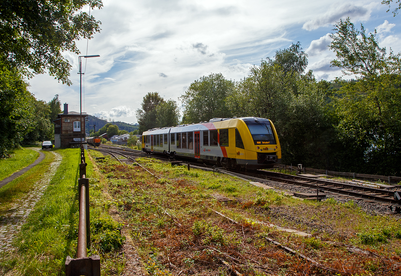 Der  VT 502 (95 80 1648 102-9 D-HEB / 95 80 1648 602-8 D-HEB) ein Alstom Coradia LINT 41 der neuen Generation der HLB (Hessische Landesbahn GmbH) erreicht am 12.07.2023 bald den Bahnhof Herdorf. Er fährt als RB 96 Hellertalbahn (Dillenburg – Haiger - Neunkirchen - Herdorf – Betzdorf/Sieg).

Hinten auf Gleis 2 muss die KSW 44 (92 80 1271 004-4 D-KSW) eine MaK G 1000 BB der KSW (Kreisbahn Siegen-Wittgenstein), mit einem Coilzug noch warten...