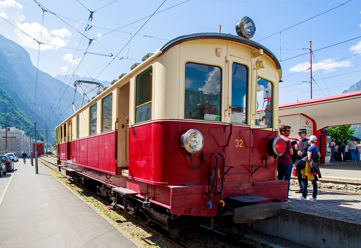 Der wunderschöne ehemalige Martigny-Châtelard-Bahn (MC) Triebwagen ABDeh 4/4 32  le tracteur  ( der Traktor ) vom Verein Train Nostalgique du Trient, ex MC BCFe 4/4, ex SBB CFeh 4/4 N°32 Baujahr 1921, am 26. Mai 2023 im Bahnhof Martigny.

Der Förderverein TNT Train Nostalgique du Trient wurde 1995 wurde 1995 gegründet, dieser bezweckt die alten Fahrzeuge der Schmalspurbahn Martigny-Châtelard-Bahn (MC) im betriebsfähigem Zustand zu halten.

Der meterspurige elektrische Personentriebwagen mit Gepäckabteil für gemischten Zahnrad- und Adhäsionsbetrieb ABDeh 4/4 32 wurde 1921 als CFeh 4/4 für die SBB (für Materialtransporte von der SBB-Station Martigny zum MC-Bahnhof Le Châtelard-Giétroz) gebaut. Während der Arbeiten am Barberine-Staudamm der SBB wurde die Martigny-Châtelard als Transport von Personal und Material ausgewählt. Da die MC (Martigny-Châtelard-Bahn) jedoch nicht über ausreichend Rollmaterial verfügte, bestellt die SBB zwei CFeh 4/4-Triebwagen Nr. 31 und 32. Die Triebwagen mit einer Leistung von 295 kW, waren zum Ziehen von Güterzügen konzipiert (daher auch ihr Spitznamen „der Traktor“), verfügten aber auch über ein großes Frachtabteil sowie ein Fahrgastabteil mit 16 Sitzplätzen in der 3. Klasse. Hersteller der für das Zahnstangensystem Strub konstruierten Triebwagen waren die SWS - Schweizerischen Waggonfabrik Schlieren (mechanischen Teil), die Schweizerischen Lokomotiv- und Maschinenfabrik in Winterthur (Drehgestelle) und die MFO - Maschinenfabrik Oerlikon (elektrische Teil). Neben diesem Triebwagen 32 wurde noch ein weiterer mit der Nr. 31 gebaut, dieser wurde im Herbst 2011 nach Vandalismus und Beschädigung leider abgebrochen. Bis 1926 waren die beiden Triebwagen 31 und 32 Eigentum der SBB (CFF). 

Nach Abschluss der Arbeiten im Jahr 1926 wurden die Triebwagen von der MC übernommen (gekauft) und mit einem zusätzlichen Fahrgastraum der 2. Klasse mit 16 Sitzplätzen ausgestattet und in BCFeh 4/4 umbenannt, nach der Klassenreform dann zu ABDeh 4/4. Seit 1996 ist der Triebwagen beim Verein Train Nostalgique du Trient

Ehemaligebezeichnungen:
SBB / CFF CFeh 4/4 - 32 (bis 1926)
MC CFeh 4/4 – 32 (bis 1935)
MC BCFeh 4/4 – 32 (ab 1935)
MC ABFZeh 4/4 - 32
MC ABDeh 4/4 - 32 (ab 1962)

TECHNISCHE DATEN:
Hersteller: SWS, MFO, SLM
Gebaute Anzahl: 2
Spurweite: 1.000 mm (Meterspur)
Achsfolge: Bozz' Bozz'
Zahnstangensystem: Strub (bzw. Riggenbach)
Länge über Kupplung: 15.940 mm 
Drehzapfenabstand: 7.850 mm 
Breite: 2.700 mm
Höhe: 3.400 mm
Leergewicht: 40,5  t
Dienstgewicht: 43 t
Leistung: 4 x 100 PS = 400 PS (295 kW)
Höchstgeschwindigkeit mit Adhäsionsantrieb: 28 km/h
Höchstgeschwindigkeit mit Zahnradantrieb: 9 km/h 
Antriebsart: Elektrisch über Oberleitung oder seitlicher Stromschiene
Fahrleitungsspannung: 850 V DC (=) (ursprünglich 750 V DC)
Sitzplätze: 32 (je 16 in der 1. und 2. Klasse)
Beschaffungspreis: 49.779.- Franken

Die Martigny-Châtelard-Bahn (Streckennummer 132), abgekürzt MC, (französisch: Chemin de fer Martigny–Châtelard) ist eine 18 km lange meterspurige Bahnstrecke mit Zahnstangenabschnitten (System Strub) mit bis zu 200 ‰ Neigung, in den Adhäsionsabschnitten mit bis zu 70 ‰ Neigung. Die Strecke führt Martigny, Vernayaz MC, Salvan, Les Marécottes, Finhaut und Le Châtelard VS bis zum französischen Bahnhof Vallorcine. In Frankreich verläuft dann die 34 km lange SNCF-Strecke (SNCF KBS 514) von Vallorcine über Chamonix-Mont-Blanc (Anschluss zur Montenvers-Bahn) nach Saint-Gervais-Le Fayet.
