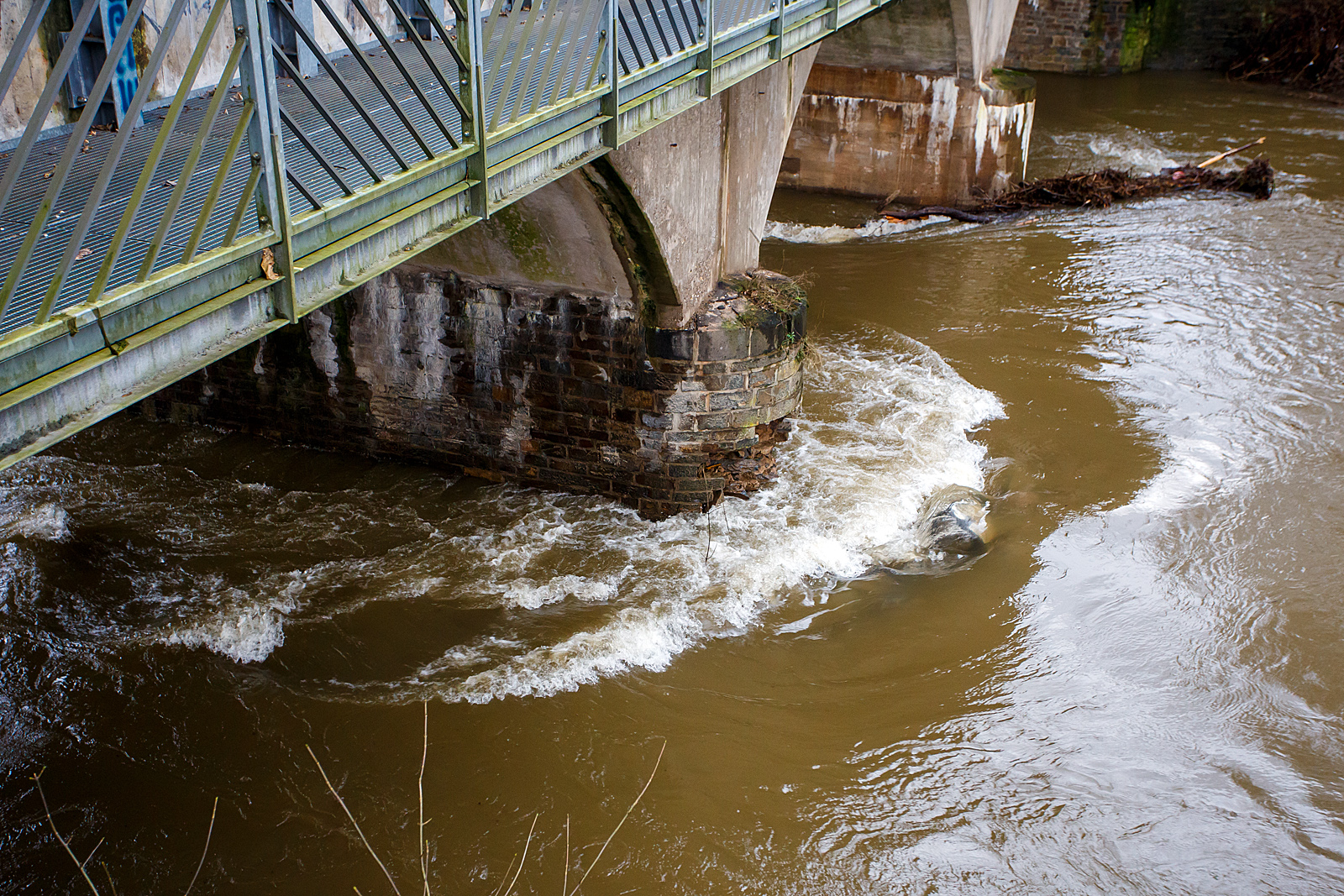 Detailbild von dem betroffenen Fundament des Brückenpfeilers der Eisenbahn-Siegbrücke mit Fußgängersteg in Kirchen (Sieg), der KBS 460 Siegstrecke. Wie weit der Schaden im/unter Wasser ist kann man nicht erkennen, aber ich würde es auch nicht verantworten wollen. Hier am 03.01.2024.