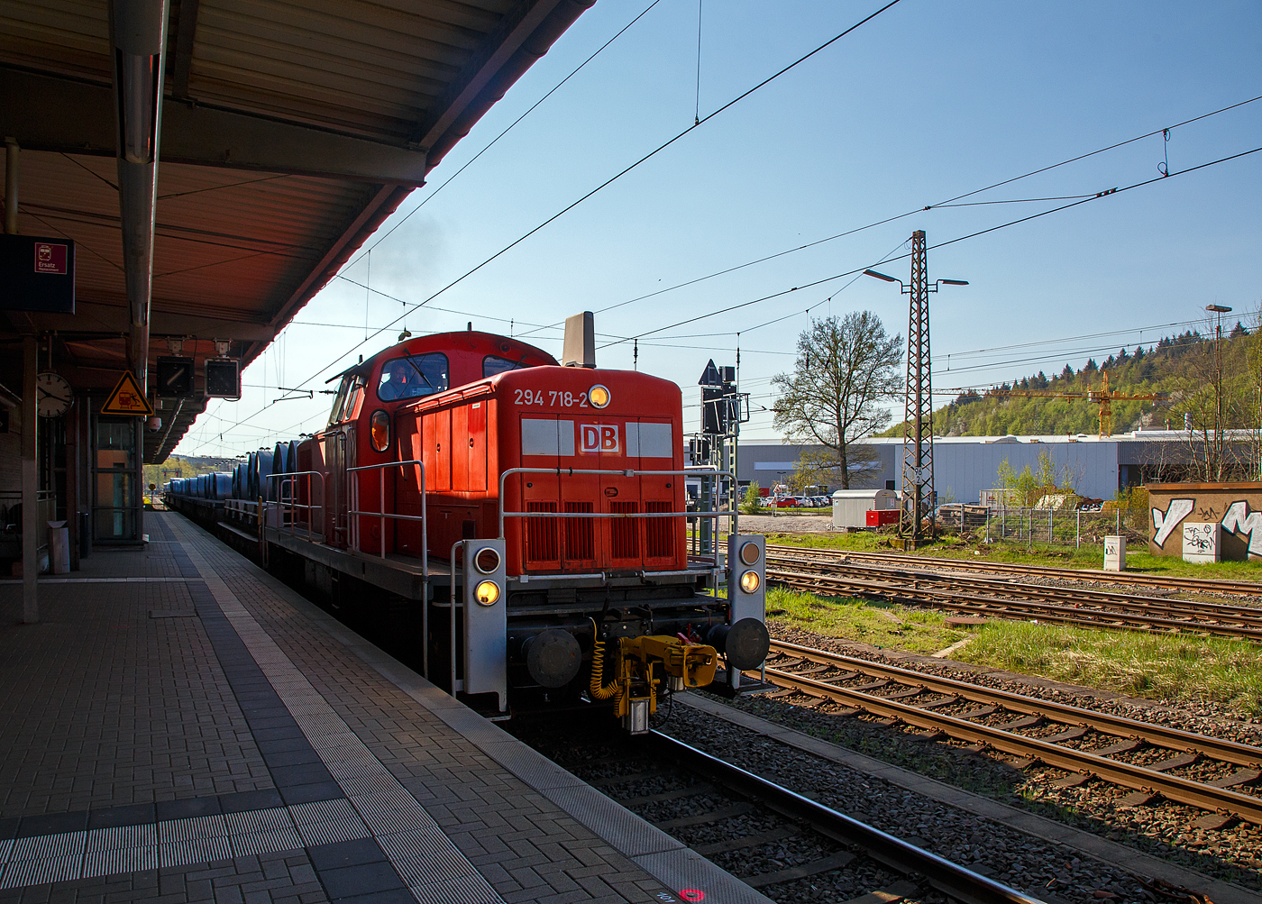 Die 294 718-2 (98 80 3294 718-2 D-DB), eine remotorisierte V 90 der DB Cargo AG fährt am 20.04.2018, mit einem Warmband-Coilzug vom Rbf Kreuztal nach Ferndorf, durch den Bahnhof Kreuztal.

Die Lok wurde 1971 bei MaK in Kiel unter der Fabriknummer 1000526 gebaut und als 290 218-3 an die DB geliefert. Die Ausrüstung mit Funkfernsteuerung (Typ Krauss-Maffei) und Umzeichnung in 294 218-3 erfolgte 1996. Im Jahr 2002 erfolgte durch die DB Fahrzeuginstandhaltung GmbH, in Cottbus eine Remotorisierung durch einen neuen MTU 90° V-8-Zylinder-Dieselmotor mit Common-Rail-Einspritzsystem, Abgas-Turbolader und Ladeluftkühlung, vom Typ 8V 4000 R41. Der Motor ist auf eine Leistung von 1.000 kW (1.341 PS) bei 1.800 U/min gedrosselt. Auch wurden eine neue Lüfteranlage und ein neuer Luftpresser eingebaut, zudem bekam die Lok ein Umlaufgeländer. Durch die Remotorisierung und den Umbau erfolgte auch die Umzeichnung in die heutige 294 718-2.