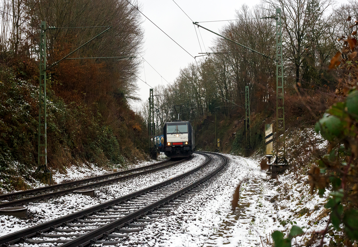 Die an die Viking-Rail ApS (mit Sitz im dänischen Padborg) vermietete 185 407-4 (91 80 6185 407-4 D-BRLL) der BRLL - Beacon Rail Leasing GmbH (Grünwald) fährt am 10 Januar 2025 mit einem Tank-Containerzug durch Betzdorf (Sieg) in Richtung Köln.

Die TRAXX F140 AC2 wurde 2011 von der Bombardier Transportation in Kassel unter der Fabriknummer 34961 gebaut und an die MRCE - Mitsui Rai Capital Europe B.V. (91 80 6185 407-4 D-DISPO geliefert. Sie hat die Zulassungen für Schweden, Deutschland und Dänemark. Noch vor der Übernahme der MRCE, wurde die Lok im Dezember 2022 an die Beacon Rail Leasing verkauft.