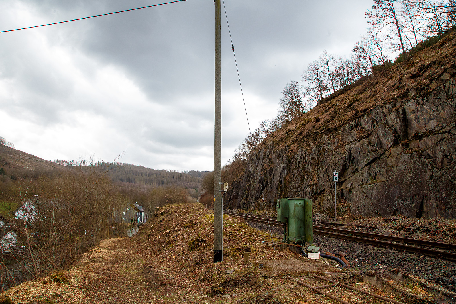 Die Hellertalbahn (KBS 462 / Strecke 2651) bei km 87,8 (bei Herdorf-Sassenroth) am 18.03.2023: Auch wenn hier min. bis zum kleinen Fahrplanwechsel im Juni 2023, wegen dem Felsstutz am 23.12.2022, kein Zug zwischen Betzdorf und dem Hp Knigsstollen (Herdorf) fhrt, ist und wird die Strecke nun gut freigeschnitten.

Bis 1987 war der Abschnitt Betzdorf–Herdorf noch zweigleisig, was man hier noch sehen kann.