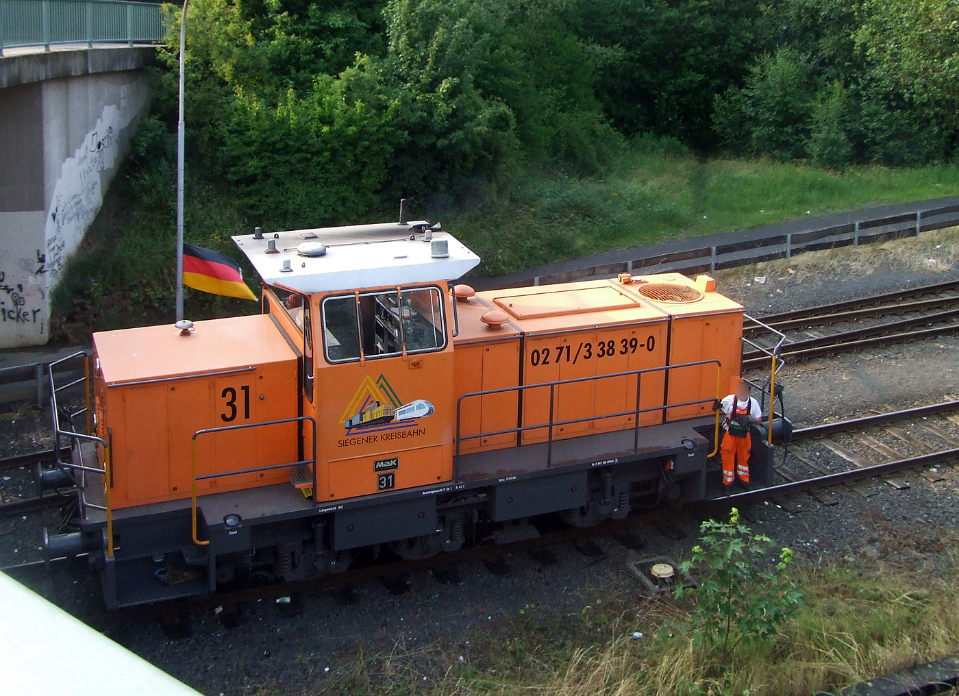 Die KSW 31, eine MaK G 763 C der Kreisbahn Siegen-Wittgenstein GmbH, rangiert am 25 Juni 2008 in Herdorf auf dem KSW-Rangierbahnhof in Herdorf (Betriebsstätte FGE -Freien Grunder Eisenbahn)

Die KSW 31 wurde 1989 von MaK in Kiel unter der Fabriknummer 700093 gebaut und als SK 31 an die Siegener Kreisbahn GmbH geliefert, welche ab Ende 2004 nun als Kreisbahn Siegen-Wittgenstein (KSW) firmiert. Die Lok wurde im Juni 2008 an die Vossloh Locomotives GmbH Kiel-Friedrichsort) verkauft und bekam nun die NVR-Nr. 92 80 0262 217-9 D-VL, bis Mitte Januar 2009 war sie dann noch an die KSW vermietet. 2009 war sie dann bei der ThyssenKrupp Steel AG im Werk Kreuztal-Ferndorf. Im Februar 2011 wurde sie dann an die VGH - Verkehrsbetriebe Grafschaft Hoya GmbH, Lok 22 (98 80 0262 217-9 D-VGH) verkauft.

Die Lokomotive MaK G 763 C ist eine dieselhydraulische Lokomotive, die von der Maschinenbau Kiel (MaK) gebaut wurde. Sie wird dem 3. Typenprogramm von MaK, das ab 1977 angeboten wurde, zugerechnet. Sie stellt die Nachfolgerin der in 18 Exemplaren gebauten MaK G 761 C dar, unterscheidet sich von dieser durch einen stärkeren MTU-Motor Reihe 396 und hat ein anderes Getriebe. Die Führerhäuser waren aus Sicherheitsgründen nicht mehr direkt vom Boden, sondern nur über den Umlauf erreichbar. Die MaK G 763 C hat drei im Rahmen sitzende Achsen, die über Gelenkwellen angetrieben werden. Sie hat eine Leistung von 560 kW und erreicht eine maximale Geschwindigkeit von bis zu 40 km/h. Sie bringt es auf eine Dienstmasse von bis zu 66 t. Ihr Tankinhalt beträgt 1.500 l.

Von der MaK G 763 C wurde zwischen 1982 und 1993 insgesamt 27 Exemplaren gebaut. Größte Abnehmer mit jeweils drei Lokomotiven waren die Siegener Kreisbahn und die Städtischen Häfen Hannover. Alle Lokomotiven befinden sich noch im Dienst. Im Deutschen Fahrzeugeinstellungsregister wurde für diese Bauart die Baureihennummer 98 80 0262 vergeben.

Technische Daten:
Spurweite: 1435 mm
Achsfolge: C
Länge über Puffer: 9.870 mm
Achsstand: 3.800 mm
größte Breite: 3.100 mm
größte Höhe über Schienenoberkante: 4.220 mm
Raddurchmesser neu: 1.000 mm
kleinster befahrbarer Gleisbogen: 40 m
Dienstgewicht: 54 - 66 t (diese 64 t)
Motor: Sechszylinder-MTU-Dieselmotor, Typ 6V 396 TC13
Leistung: 560 kW
Drehzahl: 1.800 U/min
Getriebe: Voith, Typ L3r4U2
Leistungsübertragung: hydraulisch
Höchstgeschwindigkeit: 32 - 40 km/h
Kraftstoffvorrat: 1.500 l
