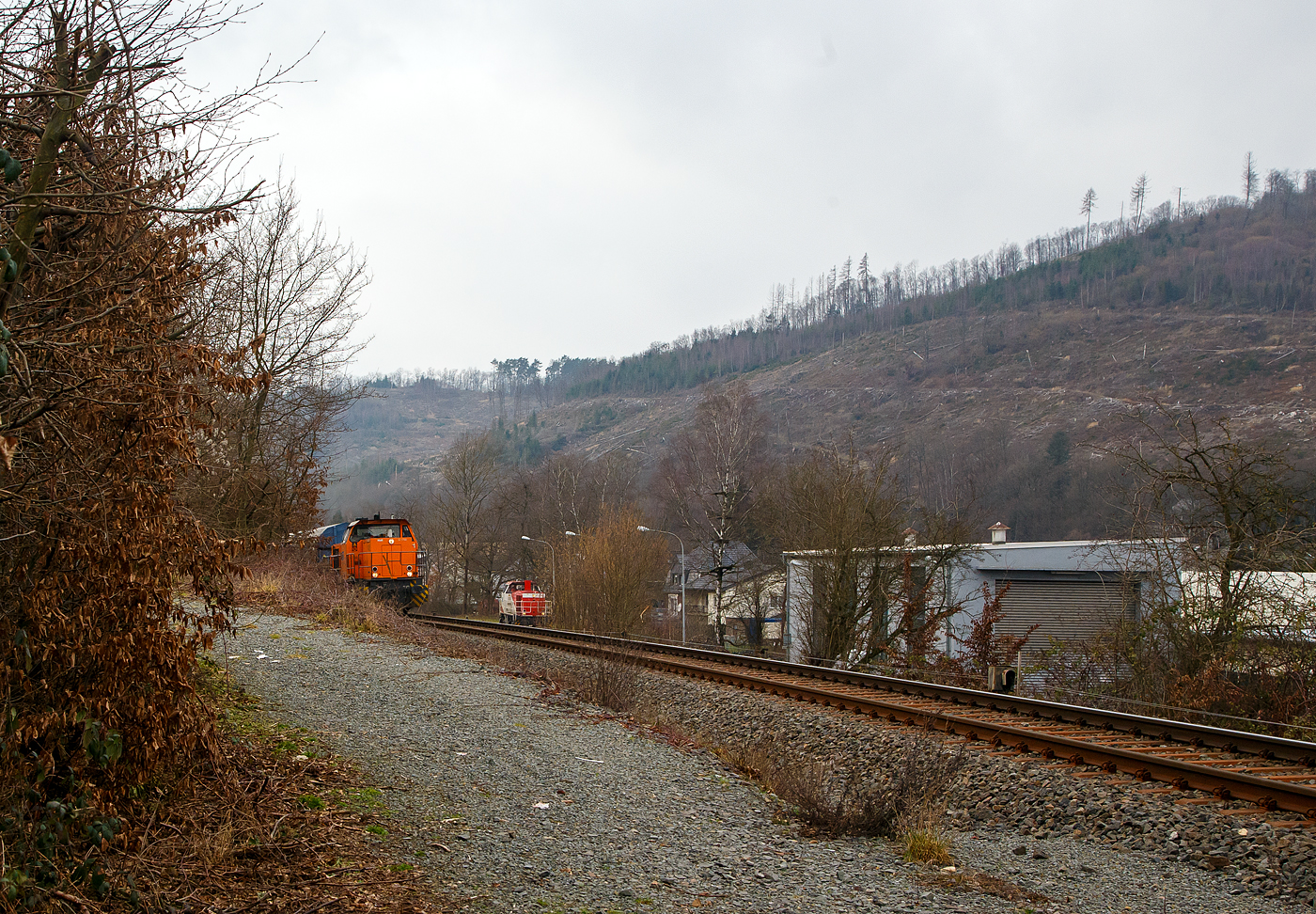 Die KSW 42 (92 80 1277 902-3 D-KSW), eine Vossloh MaK G 1700 BB der KSW (Kreisbahn Siegen-Wittgenstein), fhrt am 10.02.2023, mit einem bergabe-Gterzug, von Herdorf ber Hellertalbahn, via Haiger nach Dillenburg, whrend rechts unten am KSW Rangierbahnhof Herdorf (Freien Grunder Eisenbahn KSW NE447 / DB-Nr. 9275) die Die KSW 47 (92 80 1271 027-5 D-KSW), ex D 2 der HFM, eine Vossloh G 1000 BB steht.

Im Bild ganz rechts der Lokschuppen der KSW, ex Freien Grunder Eisenbahn.
