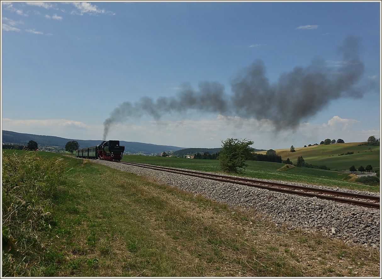 Die Lokomotive ex DR 52 8163-9 dampft durch die Landschaft des Jura bei Le Touillon.
(15.07.2023)
