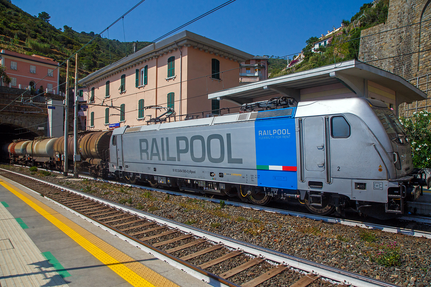 Die Railpool 494 580 (91 83 2494 580-0 I-RPOOL), eine Bombardier TRAXX F140 DC3 LM (mit Last-Mile-Modul), fährt am 22.07.2022 mit einem Kesselwagenzug durch den Bahnhof Riomaggiore (Cinque Terre) an der Italienischen Riviera in Richtung La Spezia bzw. Pisa. 

Riomaggiore ist das südlichste der fünf Dörfer der Cinque Terre (Fünf Ortschaften) und verfügt, wie die anderen Dörfer, über eine Eisenbahnstation an der Bahnstrecke Pisa–Genua (RFI Strecke-Nr. 77 / KBS 31 La Spezia–Genua), die den Ort mit den Nachbardörfern und mit La Spezia und Levanto verbindet. 