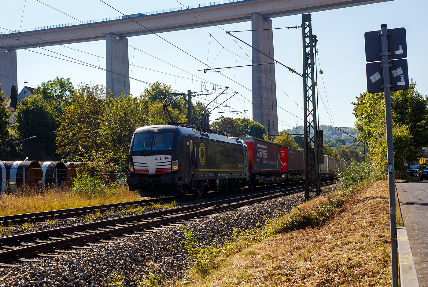 Die SIEMENS Vectron MS X4E – 664 / 193 664-0 (91 80 6193 664-0 D-DISPO) der BRCE - Beacon Rail Capital Europe (München) fährt am 21 September 2024 mit einem KLV-Zug durch Eiserfeld in Richtung Siegen. 

Die Multisystemlokomotive Siemens Vectron MS wurde 2017 von Siemens Mobilitiy in München-Allach unter der Fabriknummer 22244 gebaut. Sie wurde in der Variante A09 (Zulassungen für D / A / I) ausgeführt. Im Jahr 2022 erfolgte bie Siemens in München-Allach der Umbau in die Variante A22 und hat so die Zulassung für Deutschland, Österreich, die Schweiz, Italien und die Niederlande (D / A / CH / I / NL). So besitzt die Variante MS A22 folgende Zugsicherungssysteme: ETCS BaseLine 3, sowie für Deutschland (PZB90 / LZB80 (CIR-ELKE I)), für Österreich (ETCS Level 1 mit Euroloop, ETCS Level 2, PZB90 / LZB80), für die Schweiz (ETCS Level 2, ZUB262ct, INTEGRA), für Italien (SCMT) und die Niederlande (ETCS Level 1, ETCS Level 2, ATB-EGvv)

Die Lok wurde an die MRCE - Mitsui Rail Capital Europe GmbH in München ausgeliefert, seit September 2023 hat die Beacon Rail Metro Finance B.V. die Mitsui Rail Capital Europe B.V. (Amsterdam) und somit auch die Mitsui Rail Capital Europe GmbH im München übernommen, so firmiert sie nun als Beacon Rail Capital Europe GmbH, München (BRCE / DISPO).