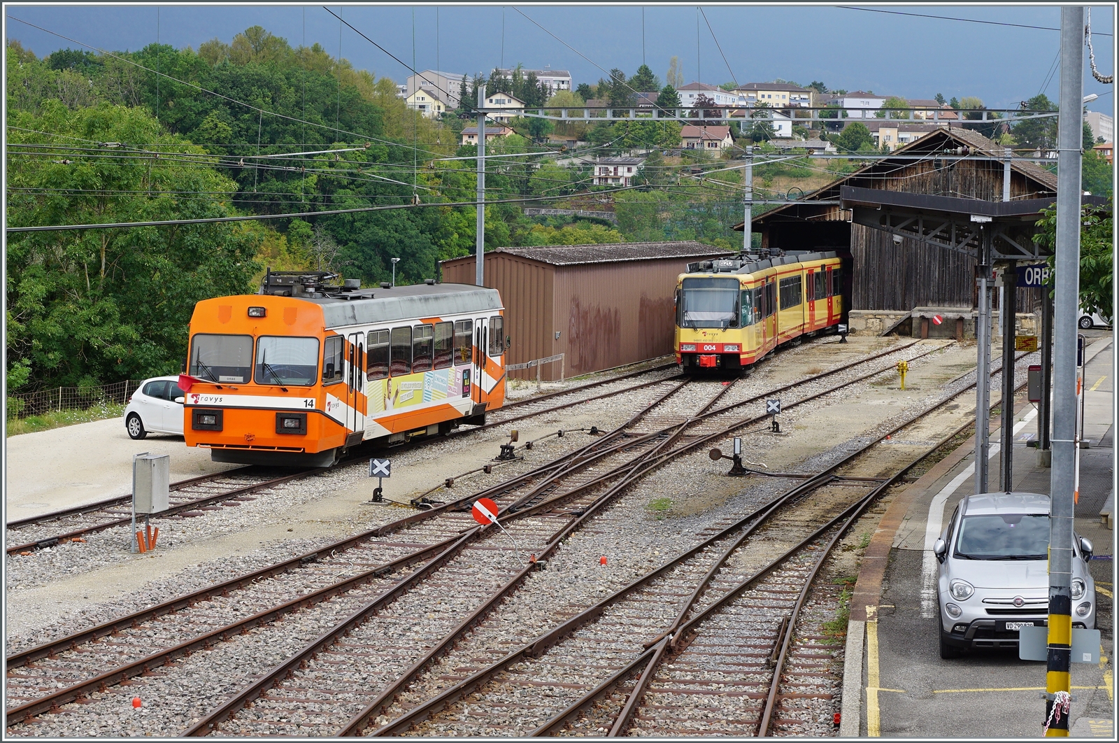 Ein Blick auf den Bahnhof von Orbe mit den beiden defekten TRAVYS Be 2/2 14 und Be 4/8 004. 

15. August 2022