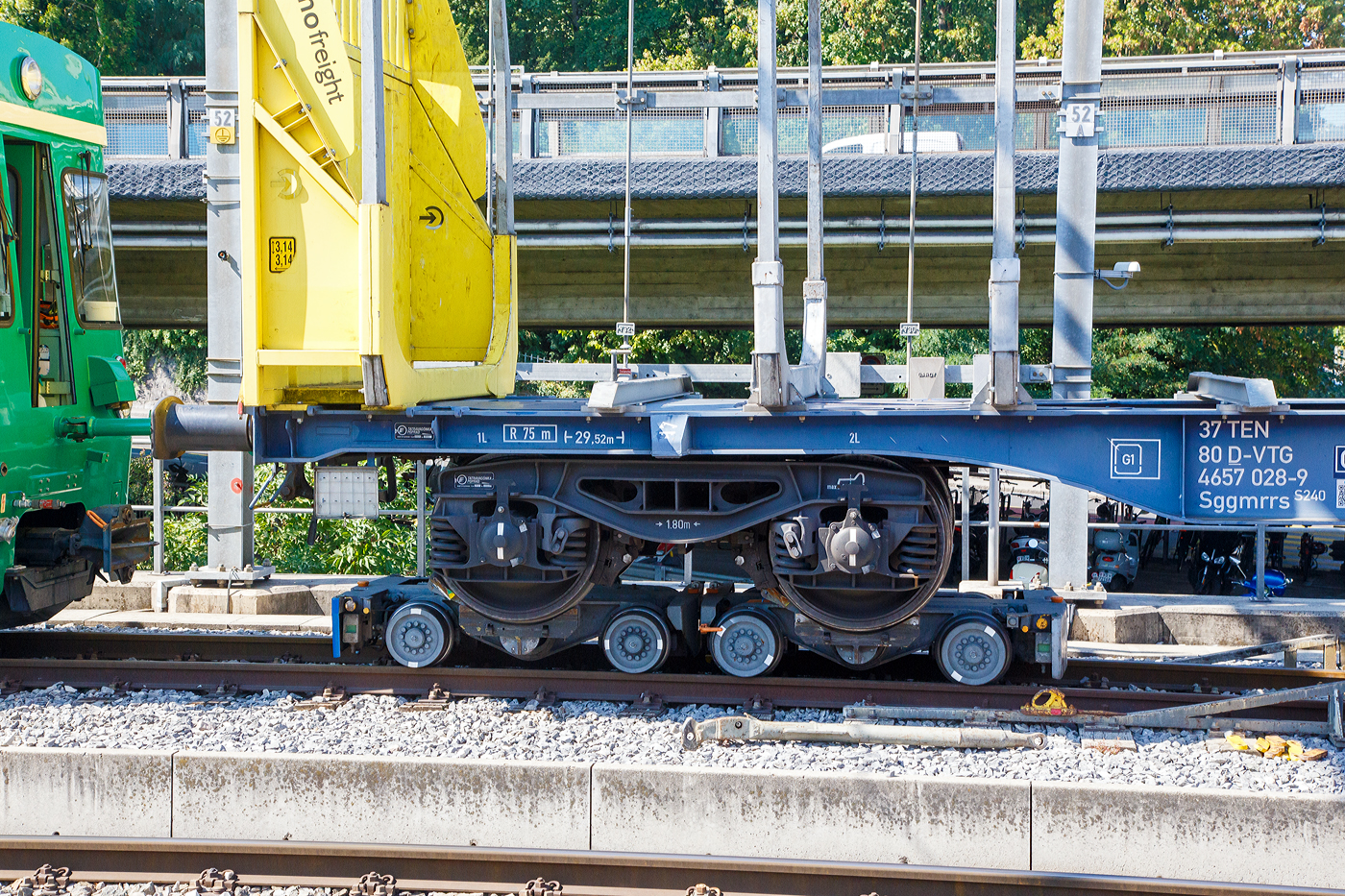 Ein normalspuriges Drehgestell des leeren 2 x vierachsiger Flachwagen in Sonderbauart (INNOFREIGHT Holz-Doppelwagen), 37 80 4657 028-9 D-VTG, der Gattung Sggmrrs S240, verladen auf zwei schmalspurige Rollböcke Ua 2xx vom Typ Vevey, am 07 September 2023 an einer Rollbockgrube beim Bahnhof Morges.

Die Rollböcke dienen zum Transport von Normalspurwagen (meist Güterwagen) auf Schmalspurgleisen (wie hier 1.000 mm). Ein Rollbock ist 1,65 t schwer und trägt jeweils eine Normalspur-Wagonachse mit einer maximalen Achslast von 22,5 t. Bei z.B. einem vierachsigen Drehgestell Wagen kommen so vier Rollböcke zum Einsatz, wobei der Wagen somit bis zu 90 t schwer sein kann.

TECHNISCHE DATEN:
Spurweite: 1.000 mm
Achsanzahl: 2
Eigengewicht: 1,65 t
Traglast: 22,5 t 

Ein Rollbock ist ein meist zweiachsiges Schienenfahrzeug (Wagen), mit dem ein andersspuriges Eisenbahnfahrzeug auf der Spurweite des Rollbocks befördert werden kann. In Süddeutschland wird er auch als Rollschemel bezeichnet, nicht aber in der Schweiz, wo dieses Wort einen Rollwagen bezeichnet. Entwickelt wurde der Rollbock 1881 von Paul Langbein (1842–1908).

Funktion:
Durch den Einsatz von Rollböcken entfällt im Güterverkehr das Umladen der Güter in Fahrzeuge der anderen Spurweite. Das Aufbocken von Personenwagen war nicht üblich, da die Reisenden selbst relativ leicht die Fahrzeuge wechseln konnten und das Kipp-Risiko bei Personenbeförderung nicht akzeptabel war. Zu besonderen Anlässen wurden aber Spezialwagen verladen, beispielsweise Salon- oder Kinowagen. Grundsätzlich ist anzumerken, dass es, insbesondere in Deutschland, kein zusammenhängendes Schmalspurnetz, ähnlich jenem in Normalspur, gibt oder gab. Daher war eine weitgehende Normung und Standardisierung, die bei den normalspurigen Eisenbahnen die Interoperabilität sicherstellt, nicht zwingend und fand nicht statt. Folglich kam es zu zahlreichen technischen Insellösungen, auch bei den Rollböcken. Die grundsätzliche Funktion ist aber stets dieselbe. Neben technischen Unterschieden waren daraus folgend die Vorschriften für den Betrieb verschieden, wobei die Vorschriften zum Teil die Technik beeinflussten, zum Teil aber auch in der Folge der technischen Voraussetzungen erlassen wurden.

Rollböcke werden seitens der Eisenbahnindustrie im Übrigen auch dafür eingesetzt, andersspurige Fahrzeuge über Normalspur vom Hersteller zu Testeinrichtungen oder zu ihrem Einsatzgebiet zu transportieren. So setzt die RailAdventure GmbH solche Fahrzeuge – bei ihr Loco Buggys genannt – ein.

Technik
Der Rollbock ist ein schmalspuriges Fahrzeug mit sehr kurzem Achsstand (ähnlich einem Drehgestell), auf dem die Räder jeweils eines Radsatzes des Normalspurwagens verankert werden. Beladen wird der Rollbock von einer speziellen Rollbockgrube aus. Abhängig von der konkreten Ausgestaltung der Rollböcke konnten auch dreiachsige Wagen aufgebockt werden. 

Güterwagen auf Rollböcken (oder Rollwagen) können zu ganzen Güterzügen zusammengestellt werden. Je nach örtlicher Betriebsvorschrift konnten schmalspurige Personenwagen in die Züge eingereiht werden, häufig waren die Reihungsfolgen reglementiert. Zum Teil waren bzw. sind die Rollböcke mit dem jeweiligen Bremssystem (Druckluft, Saugluft) oder Heberleinbremse der Schmalspurbahn ausgerüstet, es gab aber auch ungebremste Rollböcke. Einige Bahnen stellten in diesem Fall so genannte Bremswagen in die Züge ein, die ballastiert waren, um größeres Bremsvermögen zu besitzen. Teilweise wurden die Bremsleitungen der Normalspurwagen mitverwendet und die Rollbockbremsen über T-Stücke an diese angeschlossen. Normalspurwagen auf Rollböcken werden entweder direkt miteinander gekuppelt oder die Rollböcke mittels Kuppelstangen verbunden. Bei der direkten Kupplung sind diese „lang zu machen“, das heißt, nicht straff anzuziehen, da die Puffer die Wagen in den häufig engen Radien sonst von den Rollböcken drücken würden. Die Verbindung mit dem Zugfahrzeug kann ebenfalls über Kuppelstangen erfolgen. Es gibt aber auch die Möglichkeit, so genannte Pufferwagen zu verwenden. Diese schmalspurigen Wagen besitzen Zug- und Stoßvorrichtungen, die in Ausführung und Höhe zu jenen der aufgebockten Normalspurwagen passen und somit als Adapter dienen. Es wurden auch Lokomotiven mit solchen angepassten Normalspur-Zug-und-Stoßvorrichtungen verwendet.

Rollböcke nach dem System Vevey
Um den beim System Langbein personal- und zeitaufwändigen Verladevorgang zu vereinfachen, entwickelte die schweizerische Bahngesellschaft YSteC 1974 ein neues Prinzip. Hierbei wird die Achse des Normalspurwagens nicht mehr fixiert. Der Wagen steht mit seinen Rädern in speziell geformten Mulden. Derartige Rollböcke, als System „Vevey“ von den Ateliers de constructions mécaniques de Vevey (ACMV) in Serie gefertigt, werden bei mehreren Bahnen in der Schweiz und einer Bahn in Deutschland (HSB) eingesetzt. Der Hauptunterschied zum klassischen Rollbock ist, dass das Aufbocken bei langsamer Fahrt automatisch geschieht. Somit sind zahlreiche Unannehmlichkeiten und Gefährdungspotenziale behoben, weswegen beispielsweise die Harzer Schmalspurbahnen ihre Rollwagen durch solcherlei Rollböcke ersetzt haben, ähnlich wie zuvor diverse Schweizer Bahnen.

Die mögliche Rationalisierung konnte aber nicht verhindern, dass der Güterverkehr auf zahlreichen Schmalspurbahnen dennoch eingestellt wurde. Rollbockanlagen im kommerziellen Betrieb gibt es nur noch in Nordhausen, Langenthal, Morges und Yverdon, die Anlage in Worblaufen dient noch Diensttransporten. In Interlaken Ost wurde 2021 eine neue Rollbockanlage erstellt.