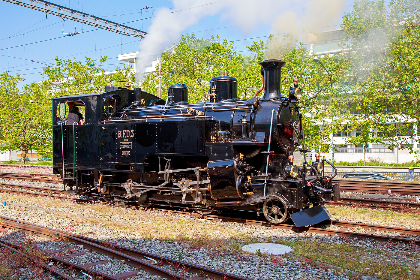 Es raucht und dampft in Vevey...
Die Dampflokomotive für gemischten Adhäsions- und Zahnradbetrieb BFD 3 HG 3/4 (Brig–Furka–Disentis-Bahn), später FO 3 (Furka-Oberalp-Bahn), heute im Bestand der Museumsbahn Blonay–Chamby, rangiert am 28.05.2023 in Vevey. Am Pfingstwochenende fand bei der das Schweizer Dampffestival 2023 / Festival suisse de la Vapeur 2023 statt.

Die Lok Nr. 3 wurde 1969 der Museumsbahn Blonay–Chamby (BC) geschenkt, während Nr. 4 als Reserve weiterhin bei der Furka-Oberalp-Bahn (FO) blieb und hauptsächlich für Nostalgiefahrten verwendet wurde. Mit Ablauf der Untersuchungsfristen wurde sie (FO 4) 1972 abgestellt. Nach einigen Stationen ging die Lok 4 im Jahr 1997 zunächst leihweise an die Dampfbahn Furka-Bergstrecke über. Anschließend wurde sie in der DFB-Werkstätte betriebsfähig aufgearbeitet und 2006 in Betrieb genommen. Die Lok wurde historisch korrekt restauriert und vollständig schwarz lackiert. Anlässlich der Eröffnung des Streckenabschnitts Gletsch–Oberwald im Jahr 2010 ging die Lok als Geschenk an die DFB über.

Auch die ehemaligen FO Loks 1 und 9, sowie Überresten der Loks 2 und 8, sind heute bei der Dampfbahn-Furka-Bergstrecke. Unter der Bezeichnung „Back to Switzerland“ kehrten die vier HG 3/4 aus Vietnam 1990 Jahre in die Schweiz zurück.

Die HG 3/4 Dampflokomotiven haben vier Zylinder, zwei außenliegende für den Adhäsionsantrieb und zwei innenliegende für den Zahnradantrieb. 

TECHNISCHE DATEN:
Länge über Puffer: 8.754 mm
Dienstgewicht: 42 t
Triebraddurchmesser: 910 mm
Laufraddurchmesser: 600 mm
Zahnrad Teilkreis: 688 mm
Zahnrad Zähne/Teilung: 18 Zähne / 120 mm (Abt 2-lamellig)
Anhängelast 110 ‰ Steigung: 60 t
Max. Geschwindigkeit Adhäsion: 45 km /h
Max. Geschwindigkeit Zahnrad: 20 km/h
Leistung: 600 PS (440 kW)
Antriebssystem: Getrennte Adhäsions- & Zahnradmaschine nach System Abt als Heissdampf Vierzylinderverbundmaschine
Bremsen: Vakuumbremse, Riggenbach'sche Gegendruckbremse
Steuerung Adhäsion: Walscherts Kolbenschieber
Steuerung Zahnrad: Joy Kolbenschieber
Zylinderdurchmesser Adhäsion: 420 mm
Zylinderdurchmesser Zahnrad: 560 mm
Kesseldruck: 14 bar
Rostfläche / Heizfläche:1,3 m² / 63 m²
Siede- / Rauchrohre: 95 / 15 Rohre
Kesselwasser-Inhalt: 2,6 m³
Wasservorrat: 3,15 m³
Kohlenvorrat: ca. 1,3 t
