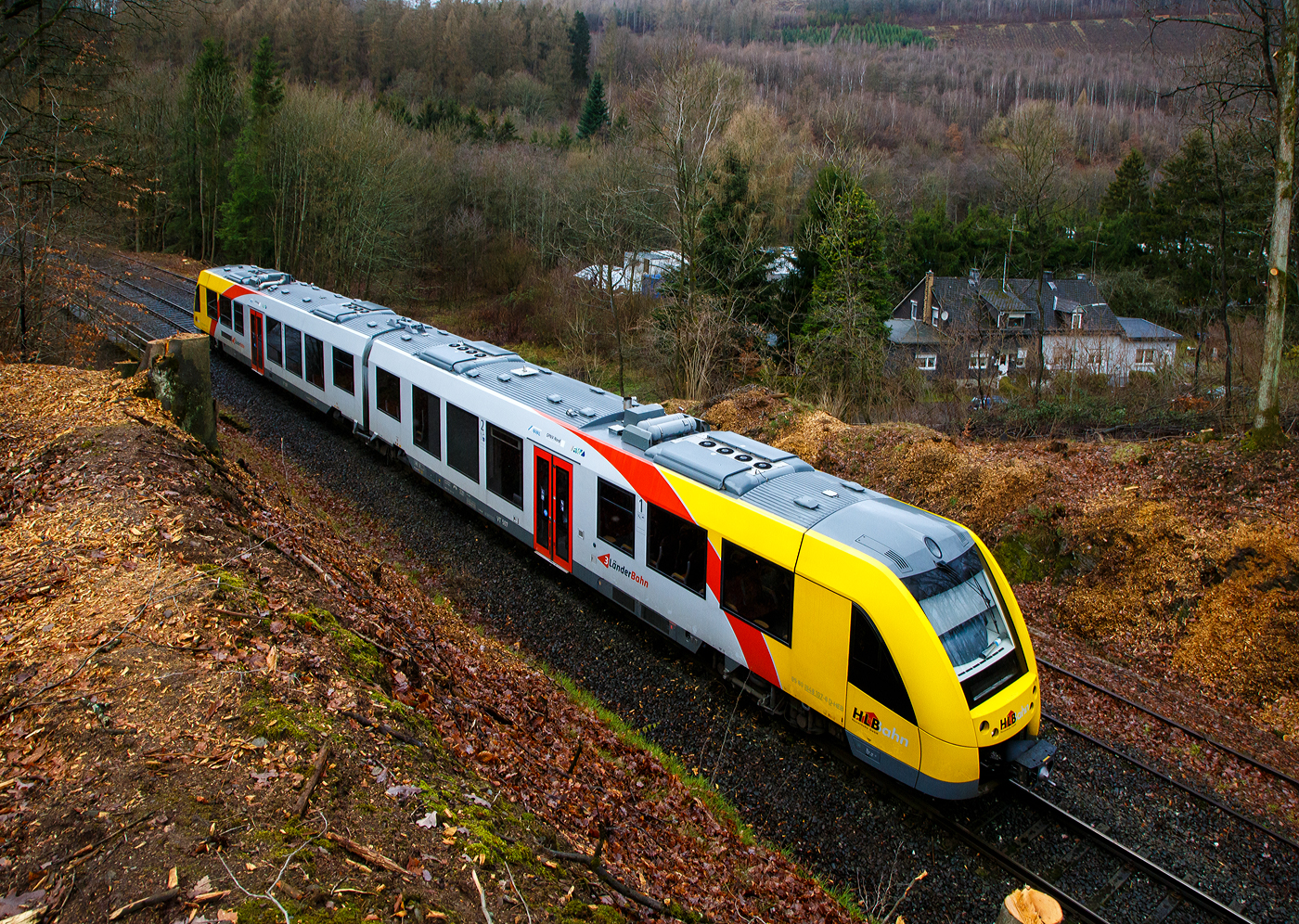 Glück im Unglück.....
Herdorf den 23. Dezember 2022 ca. 18:15 Uhr (Bild vom 24.12.)
Zug entgleist in Herdorf kurz hinter dem Hp  Königsstollen (bei km 88,4) – Fahrgäste kommen mit dem Schrecken davon. Wie sich kurze Zeit später herausstellte hatte ein Erdrutsch dazu geführt. Hier im Bild der havarierte Triebwagen VT 507.
	
Der Diesel-Triebwagen VT 507 (95 80 1648 107-8 D-HEB / 95 80 1648 607-7 D-HEB), ein Alstom Coradia LINT 41 der neuen Generation, der HLB (Hessische Landesbahn GmbH), war am 23.12.2022 (Bf Herdorf ab 18:10 Uhr), als RB 96  Hellertalbahn  Neunkirchen - Herdorf - Betzdorf (Umlauf 61790) von Herdorf nach Betzdorf unterwegs. Kurz hinter dem Hp Königsstollen (bei km 88,4) kam es zu einen Erdrutsch zum Teil mit Felsbrocken, als gerade der Triebwagen die Stelle passierte, entgleiste das vorderen Drehgestell. Der Triebwagen mit Passagieren ist im Gleisbett geblieben und nach ca. 100 m er an der Eisenbahnbrücke, die über die Landesstraße führt, zum Stehen. Die ca. 15 Fahrgästen und der Treibfahrzeugführer kamen Dankbarerweise nicht zu Schaden. Da der Hp  Königsstollen ein Bedarfshalt ist, reduziert (wenn er nicht gehalten hat) der Treibfahrzeugführer zum Glück eh die Geschwindigkeit, in voller Fahrt hätte es anders ausgehen können.

Der Treibfahrzeugführer erklärte den Fahrgästen die Situation. Kurze Zeit später trafen die Rettungskräfte ein. Dank einer als provisorische Treppe umfunktionierten Steckleiter, an der Böschung am Wiederlager der Brücke, konnten Feuerwehrleute die Fahrgäste innerhalb von 15 Minuten wohlbehalten nach unten zur Landesstraße geleiten.

Die Polizei gibt als Ursache für den Erdrutsch die Witterungsbedingen an. Die Strecke bleibt bis mindestens Dienstag 27.12.2022 gesperrt sein, weil ein Spezialzug zur Bergung benötigt wird. Neben Erdreich sind auch massive Felsbrocken infolge des Hangrutsches auf dem Gleisbett gelandet, diese müssen auch erst weggeräumt werden, dafür braucht man auch Großgerät und über die Feiertage muss man auch erstmal noch eine Firma bekommen.

Im Einsatz waren neben dem Rettungsdienst und Polizei 40 Kräfte der Löschzüge Herdorf, Sassenroth und Daaden. Die anliegende Landesstraße musste aufgrund der eingesetzten Rettungskräfte ebenfalls voll gesperrt werden. Die Ermittlungen wurden von der zuständigen Bundespolizei übernommen.

Interessant ist die Tatsache das auf der einen Seite vom Gleis bereits umfangreiche Hangsicherungsmaßnahmen stattgefunden haben. Und die andere Seite noch nicht gesichert war.

Quellen: Rhein Zeitung, DPA und eigene Recherchen

Link zum Artikel der Rhein Zeitung:
http://www.rhein-zeitung.de/region/aus-den-lokalredaktionen/kreis-altenkirchen_artikel,-zug-entgleist-bei-herdorf-fahrgaeste-kommen-mit-dem-schrecken-davon-_arid,2486964.html
