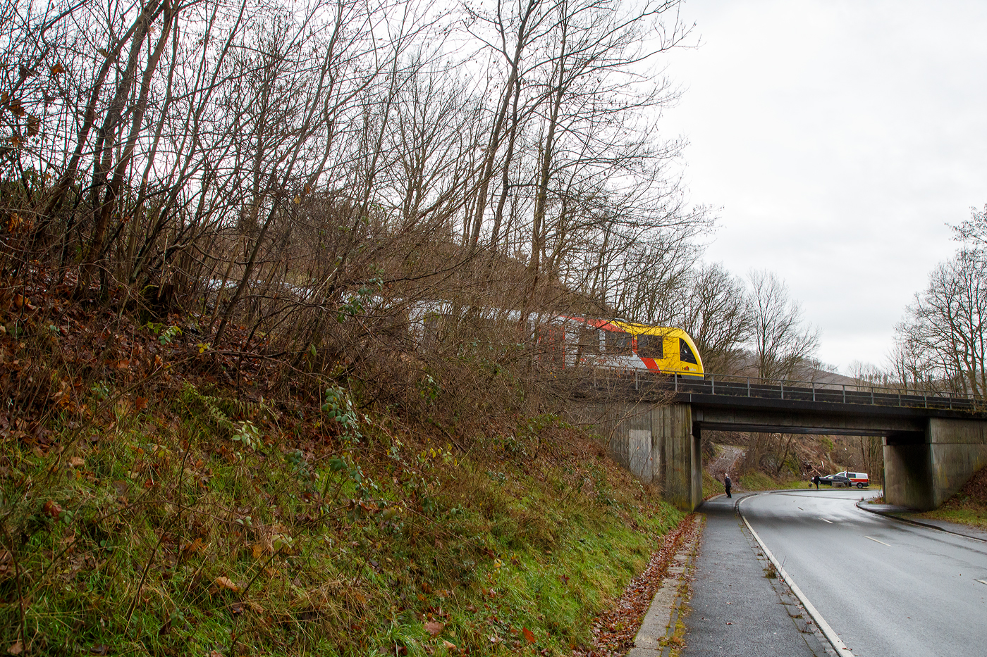 Glück im Unglück.....
Herdorf den 23. Dezember 2022 ca. 18:15 Uhr (Bild vom 24.12.)
Zug entgleist in Herdorf kurz hinter dem Hp  Königsstollen (bei km 88,4) – Fahrgäste kommen mit dem Schrecken davon. Wie sich kurze Zeit später herausstellte hatte ein Erdrutsch dazu geführt. Hier im Bild der havarierte Triebwagen VT 507.
	
Der Diesel-Triebwagen VT 507 (95 80 1648 107-8 D-HEB / 95 80 1648 607-7 D-HEB), ein Alstom Coradia LINT 41 der neuen Generation, der HLB (Hessische Landesbahn GmbH), war am 23.12.2022 (Bf Herdorf ab 18:10 Uhr), als RB 96  Hellertalbahn  Neunkirchen - Herdorf - Betzdorf (Umlauf 61790) von Herdorf nach Betzdorf unterwegs. Kurz hinter dem Hp Königsstollen (bei km 88,4) kam es zu einen Erdrutsch zum Teil mit Felsbrocken, als gerade der Triebwagen die Stelle passierte, entgleiste das vorderen Drehgestell. Der Triebwagen mit Passagieren ist im Gleisbett geblieben und nach ca. 100 m er an der Eisenbahnbrücke, die über die Landesstraße führt, zum Stehen. Die ca. 15 Fahrgästen und der Treibfahrzeugführer kamen Dankbarerweise nicht zu Schaden. Da der Hp  Königsstollen ein Bedarfshalt ist, reduziert (wenn er nicht gehalten hat) der Treibfahrzeugführer zum Glück eh die Geschwindigkeit, in voller Fahrt hätte es anders ausgehen können.

Der Treibfahrzeugführer erklärte den Fahrgästen die Situation. Kurze Zeit später trafen die Rettungskräfte ein. Dank einer als provisorische Treppe umfunktionierten Steckleiter, an der Böschung am Wiederlager der Brücke, konnten Feuerwehrleute die Fahrgäste innerhalb von 15 Minuten wohlbehalten nach unten zur Landesstraße geleiten.

Die Polizei gibt als Ursache für den Erdrutsch die Witterungsbedingen an. Die Strecke bleibt bis mindestens Dienstag 27.12.2022 gesperrt sein, weil ein Spezialzug zur Bergung benötigt wird. Neben Erdreich sind auch massive Felsbrocken infolge des Hangrutsches auf dem Gleisbett gelandet, diese müssen auch erst weggeräumt werden, dafür braucht man auch Großgerät und über die Feiertage muss man auch erstmal noch eine Firma bekommen.

Im Einsatz waren neben dem Rettungsdienst und Polizei 40 Kräfte der Löschzüge Herdorf, Sassenroth und Daaden. Die anliegende Landesstraße musste aufgrund der eingesetzten Rettungskräfte ebenfalls voll gesperrt werden. Die Ermittlungen wurden von der zuständigen Bundespolizei übernommen.

Interessant ist die Tatsache das auf der einen Seite vom Gleis bereits umfangreiche Hangsicherungsmaßnahmen stattgefunden haben. Und die andere Seite noch nicht gesichert war.

Quellen: Rhein Zeitung, DPA und eigene Recherchen

Link zum Artikel der Rhein Zeitung:
http://www.rhein-zeitung.de/region/aus-den-lokalredaktionen/kreis-altenkirchen_artikel,-zug-entgleist-bei-herdorf-fahrgaeste-kommen-mit-dem-schrecken-davon-_arid,2486964.html
