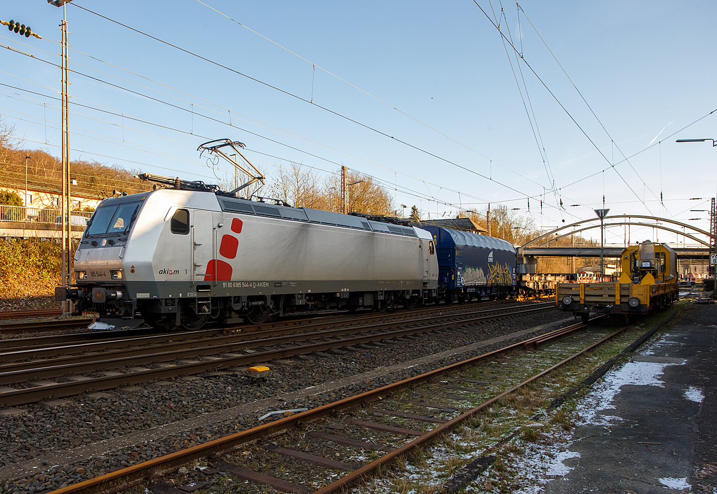 Heute am 8 Januar 2024 fegte ein bitter kalter Wind, aber endlich kam nochmal die Sonne hervor, so fuhren wir trotz der Bauerndemos nach Kreuztal, zudem ist ab morgen wegen dem GDL-Streik der Bahnverkehr lahm gelegt. Wir hatten den richtigen Weg gewählt und kamen zügig hin und zurück.

Die mit DACH-Zulassung (Deutschland, Österreich und Schweiz) an die DB Cargo AG vermietete Akiem 185 544-4 (91 80 6185 544-4 D-AKIEM), ex MRCE Dispolok (91 80 6185 544-4 D-DISPO), fährt mit einem Übergabezug (leere Coil-Wagen) vom Rbf Kreuztal in Richtung Hagen los. 

Die TRAXX F140 AC1 wurde 2005 von Bombardier Transportation GmbH in Kassel unter der Fabriknummer 33729 gebaut und an die MRCE - Mitsui Rail Capital Europe geliefert. An die AKIEM SAS wurde sie 2023 verkauft. Sie hat die Zulassungen für Deutschland, Österreich und die Schweiz (D/A/CH).
