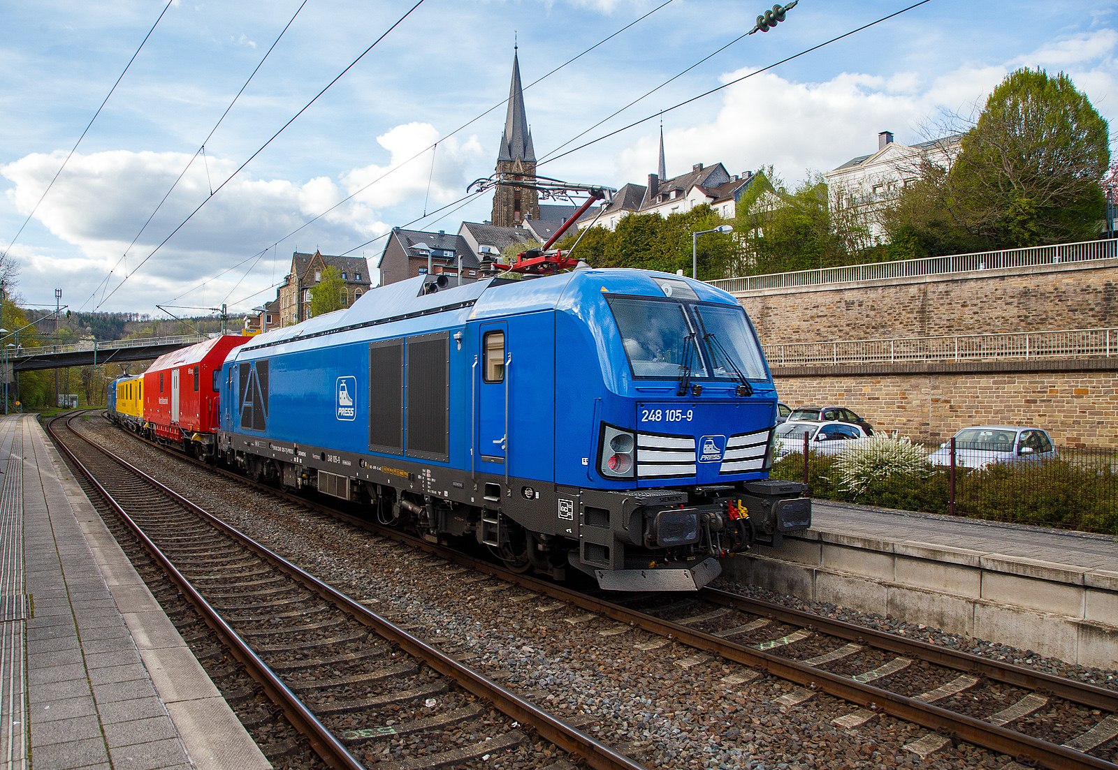 In einer ungewhnlichen Komposition (im Sandwich zweier SIEMENS Vectron Dual Mode der PRESS) fhrt ein Schienenprfzug (SPZ 3), auf Prffahrt (der Messwagen ist auf die Schiene absenkt) am 30.04.2023 durch den Bahnhof Kirchen an der Sieg in Richtung Siegen.

Hier im Detail die SIEMENS Vectron Dual Mode 248 026-7 (90 80 2248 026-7 D-PRESS) alias 248 105-9 der PRESS (Eisenbahnbau- und Betriebsgesellschaft Pressnitztalbahn mbH, Jhstadt), bzw.als Nachschuss der ganze Messzug. Die Lok wurde 2022 von SIEMENS in Mnchen-Allach unter der Fabriknummern 23168 gebaut und an die PRESS - Eisenbahnbau- und Betriebsgesellschaft Pressnitztalbahn mbH in Jhstadt geliefert. Die Vectron DM hat die Zulassung fr Deutschland fr eine Hchstgeschwindigkeit 160 km/h.