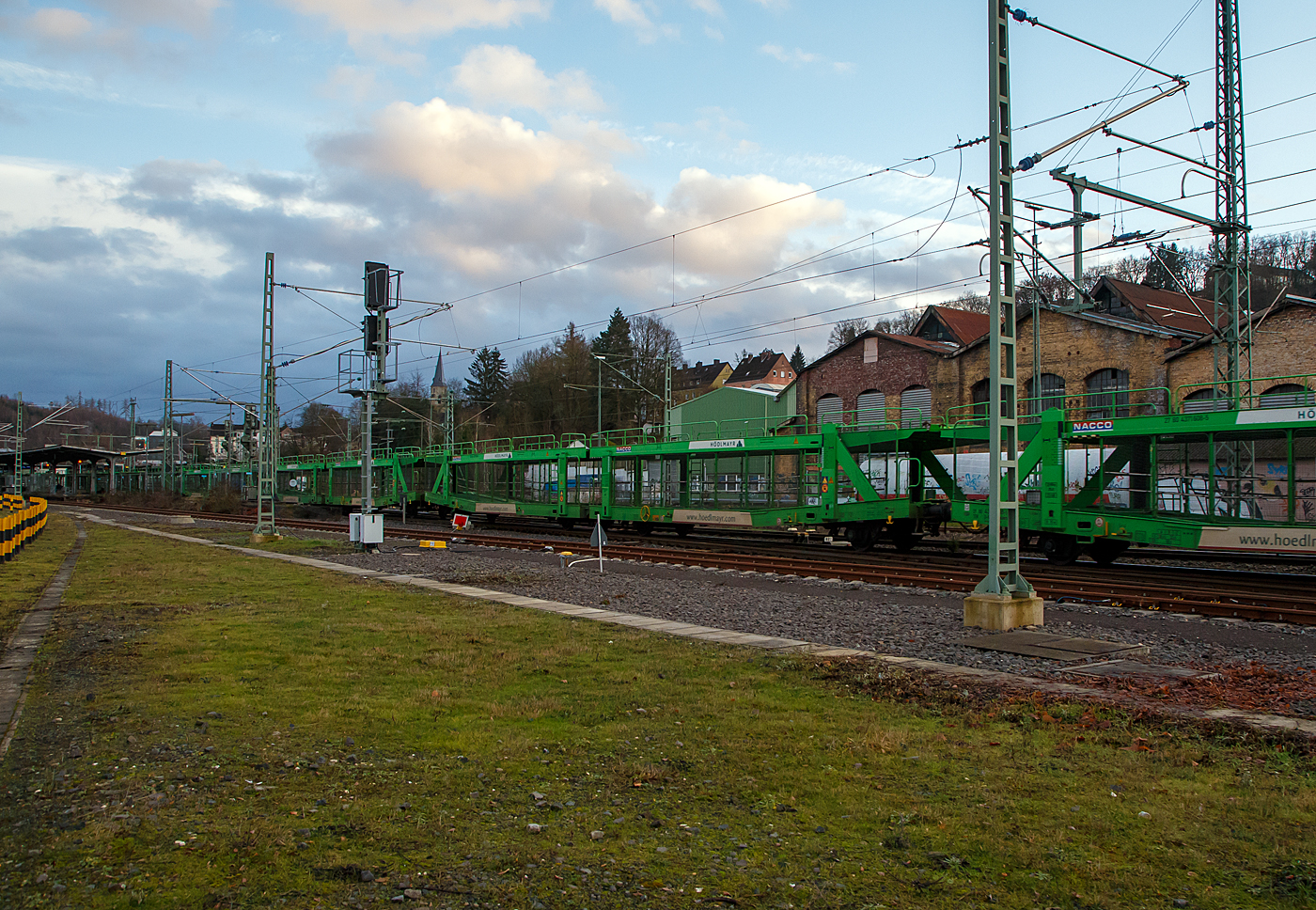 Leerer offener vierachsiger Doppelstock- Autotransportwaggon 27 80 4371 608-5 D-NACCO, der Gattung Laaers 560.1 (BA 5.854), noch registriert unter NACCO AG (gehren nun der TWA- TRANSWAGGON) am 11.01.2022 im Zugverband bei einer Zugdurchfahrt in Betzdorf (Sieg).

Diese Waggons haben zwei Ladeebenen und sind fr den europaweiten Transport geeignet. Sie werden fr den internationalen Transport von PKWs, Gelndewagen, und Vans eingesetzt und bieten maximale Flexibilitt durch eine stufenlos verstellbare obere Ladeebene. Aufgrund der hohen Lastgrenze (34t) ist der Transport von besonders schweren Fahrzeugen der genannten Typen mglich. Damit sowohl ein typenreiner Transport als auch eine Mischverladung in den unterschiedlichen Lademaen mglich ist, kann die obere Ladeebene hinsichtlich der Transportstellungen stufenlos eingestellt werden.

Die oberen Ladeebenen sind ber jeweils vier dreigngige Spindeln und Tragsulen mit dem Untergestell verbunden. Die Sulenpaare lassen sich getrennt bedienen, damit die oberen Ladeebenen an den Fahrzeugenden - notwendig zur Be- und Entladung - rampenartig gestellt werden knnen. 

TECHNISCHE DATEN:
Gattung: Laaers 560.1 (BA 5.854),
Hersteller: ELH Waggonbau Niesky GmbH, Baujahr 2017
Spurweite: 1.435 mm
Anzahl der Achsen: 4
Lnge ber Puffer : 31.000 mm
Achsabstnde: 10.000 mm / 5.160 mm / 10.000 mm
Laufraddurchmesser (neu): 840 mm (auen) / 730 mm (mittleren)
Ladelnge : 30.070 mm (unten) / 30.550 mm (oben)
Hchstgeschwindigkeit: 100 km/h (120 km/h leer)
Eigengewicht: 30.000 kg
Nutzlast: 32 t bei Streckenklasse  A, 34,0 t ab B (max. 18 t pro Ebene)
Kleinster befahrb. Gleisbogenhalbmesser: 75 m
Bremse: KE-GP-A
Verwendungsfhigkeit: TEN-GE