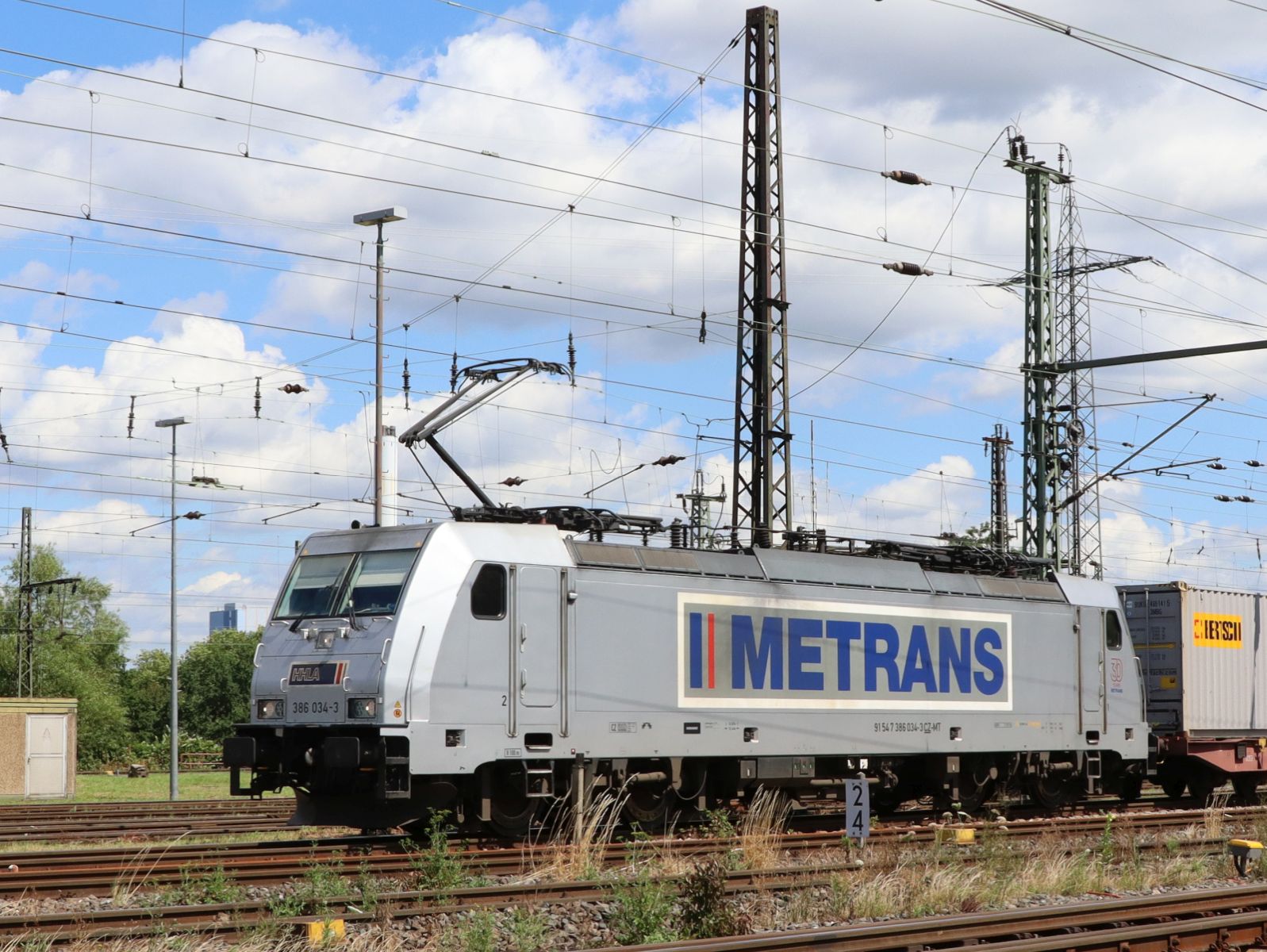 Metrans HHLA (Hamburger Hafen und Logistik AG) Lokomotive 386 034-3 (91 547 386 034-3 CZ-MT) G�terbahnhof Oberhausen West Deutschland 11-07-2024.

Metrans HHLA (Hamburger Hafen und Logistik AG) locomotief 386 034-3 (91 547 386 034-3 CZ-MT) goederenstation Oberhausen West Duitsland 11-07-2024.