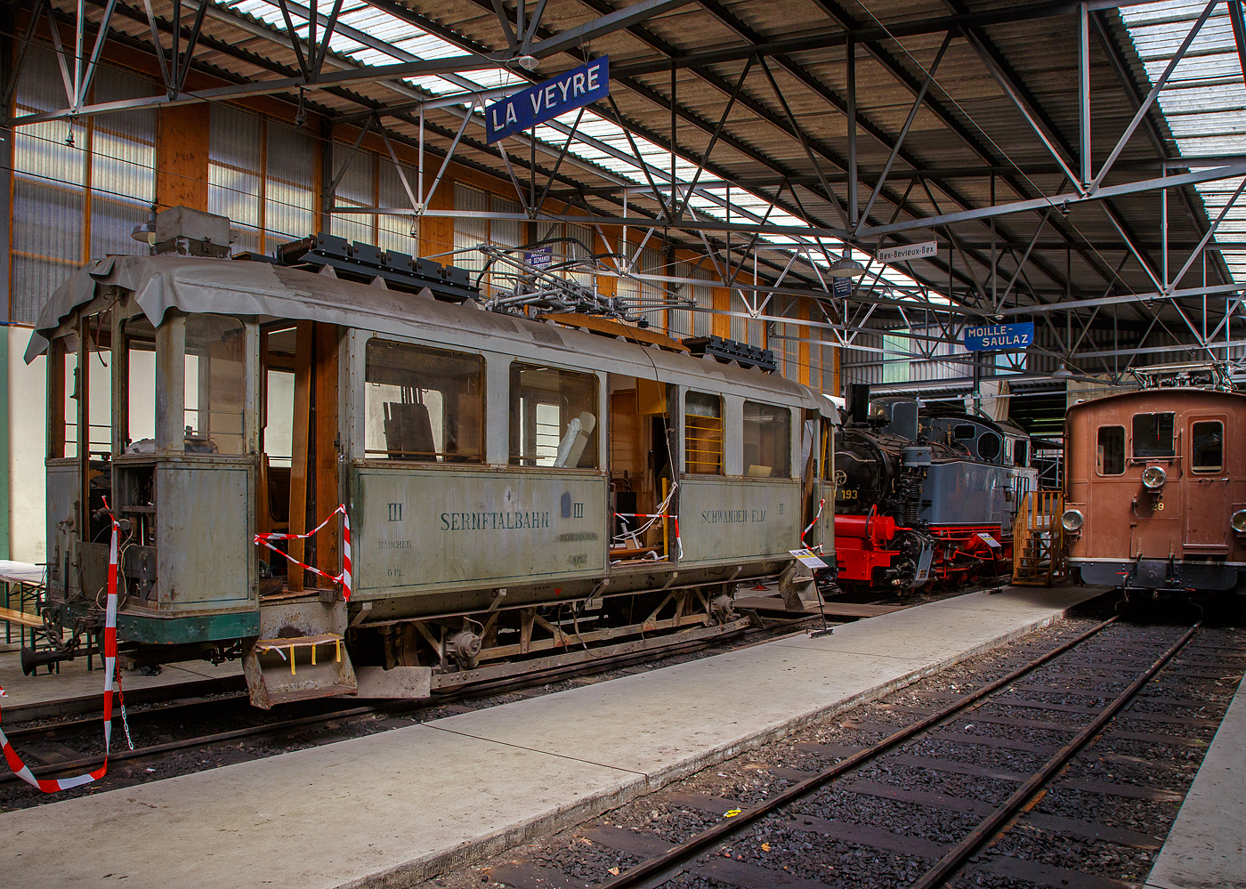 Noch in der Restaurierung (Aufarbeitungsfase) der 2./3. Klasse elektrische Personentriebwagen mit Gepckabteil der ehemalige Sernftalbahn SeTB  BCFe 2/2 4 der Museumsbahn Blonay–Chamby, am 27.05.2023 in der Halle der (BC) in Chaulin.

Der Personen- und Gepcktriebwagen wurde 1928 von der SIG (Schweizerische Industrie-Gesellschaft) in Neuhausen am Rheinfall und der elektrische Teil ist von der MFO (Maschinenfabrik Oerlikon gebaut, und an die SeTB geliefert. Die Sernftalbahn (SeTB) war eine elektrische Meterspurbahn (1.000 mm) im Schweizer Kanton Glarus, sie bestand von 1905 bis 1968) und fhrte, meist auf der Talstrae, von Schwanden aus durch das Sernftal 13,8 Kilometer entlang des namensgebenden Flusses aufwrts bis nach Elm. Die Triebwagen wurden mit Gleichstrom (750  V, spter 800 V) aus einem eigenen Wasserkraftwerk und einer Dieselmotor-Generatoren-Gruppe angetrieben. Die Betriebsleitung befand sich in Engi in der Mitte der Strecke. Nach der Einstellung der Bahn wurde der Triebwagen, wie auch der Personenwagen BC 13 und der Gterwagen K 31, 1969 an die Museumsbahn Blonay–Chamby (BC) abgegeben.

TECHNISCHE DATEN:
Spurweite: 1.000 mm
Achsfolge: A’A’
Lnge ber Puffer : 10.420 mm
Achsstand: 4.700 mm
Triebraddurchmesser: 860 mm (neu)
Eigengewicht: 15,2 t 
Leistung: 2  64 kW = 128 kW (2 x 87 PS = 174 PS)
Getriebebersetzungen: 1:5,92
Zul. Hchstgeschwindigkeit: 30 km/h 
Stromsystem: ursprnglich 850 V DC (Gleichstrom) / bei der BC 1.000 V
Stromabnehmer: 1 Scheren-Stromabnehmer, Bettigung ber Schnur
Max. Neigung : 68 ‰  (SeTB)
Sitzpltze: 6 (2. Klasse), 12 (3. Klasse) 
Gepckabteilgre: 4 m
Max. Gepck Zuladungsgewicht: 3,0  t

Quellen: BC