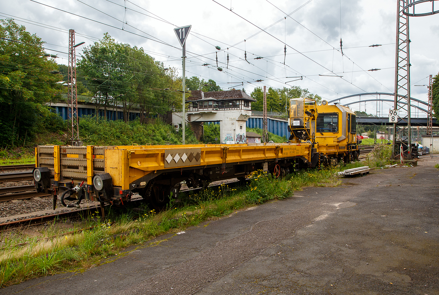 Nun haben die Anhänger H 27 (Anhänger zu den GAF 100) bei der DB eine eigene Baureihenbezeichnung und zwar BR 771. Auch die ganzen Gleiskraftwagenanhänger (H27 und die Kla´s) haben nun UIC-Nummer bekommen, sie werden eingereiht unter 99 80 9750 xxx.

DB 741 131 ein Gleisarbeitsfahrzeug GAF 100 R (Schweres Nebenfahrzeug Nr. 99 80 9420 037-0, ex 97 17 50 011 18-3), mit dem Gleiskraftwagenanhänger H27, Schweres Nebenfahrzeug Nr. D-DB 99 80 9750 276-4 (Anhängerfahrzeug BR 771 725) beide von der DB Netz AG, sind am 13.08.2023 in Kreuztal abgestellt. Da ich kein Fabrikschild finden konnte, kann ich keine ehemalige Nr. zuordnen.

Das GAF 100 R wurde 1996 von GBM (Gleisbaumechanik Brandenburg/H. GmbH) unter der Fabriknummer 52.1.124 gebaut, es hat die EBA Nummer EBA 96 P01 N023.

Das Gleisarbeitsfahrzeuge GAF 100 R ist ein Nebenfahrzeug das von der Firma GBM Gleisbaumechanik Brandenburg/H. GmbH gebaut wurde. Mit ihm können Personen (zur Mitfahrt sind 6 Personen zugelassen), Material und Ausrüstungen befördert werden können. Zudem hat es einen Palfinger PK 9001 Kran.

Der Antrieb des zweiachsigen Fahrzeuges erfolgt von einem 6 Zylinder, wassergekühlten MAM D 0826 LOH 07 Dieselmotor mit 169 kW (230 PS) Leistung über Lastschaltwendegetriebe auf die Radsatzgetriebe.

Technische Daten GAF:
Achsfolge: B
Länge über Puffer: 9.100 mm
Achsabstand: 4.800 mm
Treibraddurchmesser: 750 mm (neu)
Höchstgeschwindigkeit: 100 km/h
Eigengewicht: 16 t
Zul. Anhängelast: 40 t / (80 t mit Regelzugeinrichtung Hg 60 km/h)
Nutzlast : 5,0 t
Zur Mitfahrt zugel. Personen: 6
Der Antrieb des zweiachsigen Fahrzeuges erfolgt von einem 6 Zylinder, wassergekühlten MAN D 0826 LOH 07 Dieselmotor mit 169 kW (230 PS) Leistung über Lastschaltwendegetriebe auf die Radsatzgetriebe.

Der H 27 (Anhänger zu GAF 100) wurde von der GBM (Gleisbaumechanik Brandenburg/H. GmbH) gebaut.

Der GBM beschreibt dieses Fahrzeug wie folgt:
Der Anhänger H 27 wurde im Zusammenhang mit den Nebenfahrzeugen der Gleisbaumechanik Brandenburg entwickelt und ist in Ladeflächenhöhe, Kupplungsausführung sowie Energie - und Pneumatikanschlüssen diesen angepasst. Eine Anpassung an weitere Gerätesysteme ist nach Kundenwunsch möglich. Der Anhänger H 27 dient dem Transport von Baumaschinen, er ist aber auch gut für das Transportieren von Stückgut, Kleinteilen und Schienen geeignet. Der H 27 ist mit einem Paar einhängebarer Auffahrrampen ausgerüstet. Die Montage der Auffahrrampen kann mit 2 Personen realisiert werden. In seinen Abmessungen erfüllt er die Anforderungen nach EBO, Anlage 8. Der H 27 hat eine Spurweite von 1.435 mm. Der Fußboden des H 27 ist so dimensioniert, daß ein Befahren mit Gabelstaplern mit einer Radlast von 30 kN möglich ist. Zu den Fahrzeugenden hin ist der Fußboden geneigt ausgeführt. Dadurch verringert sich die Fußbodenhöhe von 1.000 mm über Schienenoberkante im mittleren Bereich auf 700 mm über Schienenoberkante. Durch angelegte Auffahrrampen ist es möglich, auf den H 27 mit Baumaschinen zu fahren.

Technische Daten Gleiskraftwagenanhänger:
Achsanzahl: 2
Achsabstand: 6.000 mm
Länge über Puffer: 9.750 mm
Höchstgeschwindigkeit: 100 km/h (vorgestellt 80 km/h)
Eigengewicht: 9,3 t
Zul. Anhängelast: 40 t
Nutzlast : 25,0 t
