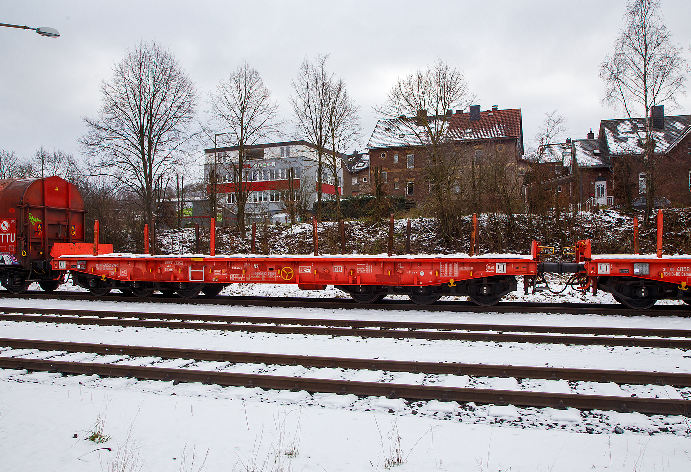 Sechsachsiger Drehgestell-Flachwagen, mit Rungen, Stirnwandklappen und klappbaren Ladeschwellen, jedoch ohne Seitenwandklappen, 31 80 4852 873-7 D-DB, der Gattung Samms 489.1, der DB Cargo AG, abgestellt am 23.01.2013  im Zugverband, auf dem KSW Rbf in Herdorf (Betriebsstätte Freien Grunder Eisenbahn - NE 447).

Der Wagen wurde 2018 von Tatravagonka a.s. in Poprad (Slowakei) gebaut. Zusammen mit Stahlkunden entwickelt die DB Schenker im Jahre 2007 einen neuen Flachwagen, der auf die Bedürfnisse der Branche noch besser eingeht. Gebaut wurden sie von dem slowakischen Hersteller Tatravagonka Poprad.

Der Wagen dient mit aufgeklappten Ladeschwellen zur Beförderung von schweren Walzprofilen und anderen sperrigen Gütern. Mit eingeklappten Ladeschwellen, also mit ebener Ladeebene, eignet er sich auch zum Transport schwerer Kettenfahrzeuge. Für das Be- und Entladen solcher Fahrzeuge sind befahrbare Stirnwandklappen vorhanden. Die Wagenbrücke ist eine in Rahmenbauweise ausgeführte Schweißkonstruktion, deren Hauptbauteile aus S355J2 (St 52) bestehen. Die Hauptbelastungen werden von den äußeren Langträgern aufgenommen. Das Kopfstück und Untergestell sind so ausgebildet, dass später ohne große Änderungen die AK eingebaut werden kann. Der Fußboden besteht aus Kiefernbohlen mit den Abmessungen 70 x 200 mm; er kann eine Radlast von 5,0 t aufnehmen. Im Fußboden sind 6 geteilte klappbare Ladeschwellen eingebaut, ebenso 6 Zurrpunkte je Längsseite. An den Außenlangträgern sind 26 Bindeösen angebracht.

Das Fahrzeug hat auf jeder Längsseite 6 Einsteckrungen und 6 zusätzliche Rungenschächte, wodurch eine variable Platzierung der Rungen ermöglicht wird (anders als bei den Vorgänger-Modellen). An jeder Stirnseite gibt es je 2 versenkbare Rungen (Fallrungen). Die Stirnwände sind umklappbar.

Durch den Einsatz der Kunststoff-Bremssohle (Cosind 810) fährt der Wagen lärmreduziert.

Hier bei der Gattung Samms 489.1 sind das Eigengewicht und die Lastgrenzen gegenüber der Gattung  Samms 489 etwas anders, so hat der Wagen eine bauartspezifische Tragfähigkeit von 104,0 t (1,5 t geringer als 489).

TECHNISCHE DATEN:
Gattung: Samms 489.1 (Gattungskennzahl 4852)
Spurweite: 1.435 mm (Normalspur)
Länge über Puffer: 16.400 mm
Drehzapfenabstand: 9.150 mm
Radsatzstand in den Drehgestellen: 2 x 1.700 mm = 3.400 mm
Raddurchmesser: 920 mm (neu)
Drehgestell-Typ: BA 714.3
Ladelänge: 15.000 mm
Ladebreite: 2.630 mm (zwischen den Rungen)
Fußbodenhöhe über SO: 1.300 mm
Ladefläche: 46 m²
Eigengewicht: 31.000 kg
Zuladung bei Lastgrenze S: 74,0 t (ab Streckenklasse D2)
Zuladung auf DB Netz bei Streckenklasse CE/D: 89,0 t (max.100 km/h)
Max. Zuladung: 104 t (bauartspezifische Tragfähigkeit)
Max. Geschwindigkeit: 100 km/h (beladen) / 120 km/h (leer)
Kleinster Gleisbogenhalbmesser: 75 m
Bauart der Bremse: KE-GP-A (K) max. 88 t
Bremssohle: Cosid 810
Handbremse: Ja
Internationale Verwendungsfähigkeit: TEN-GE
