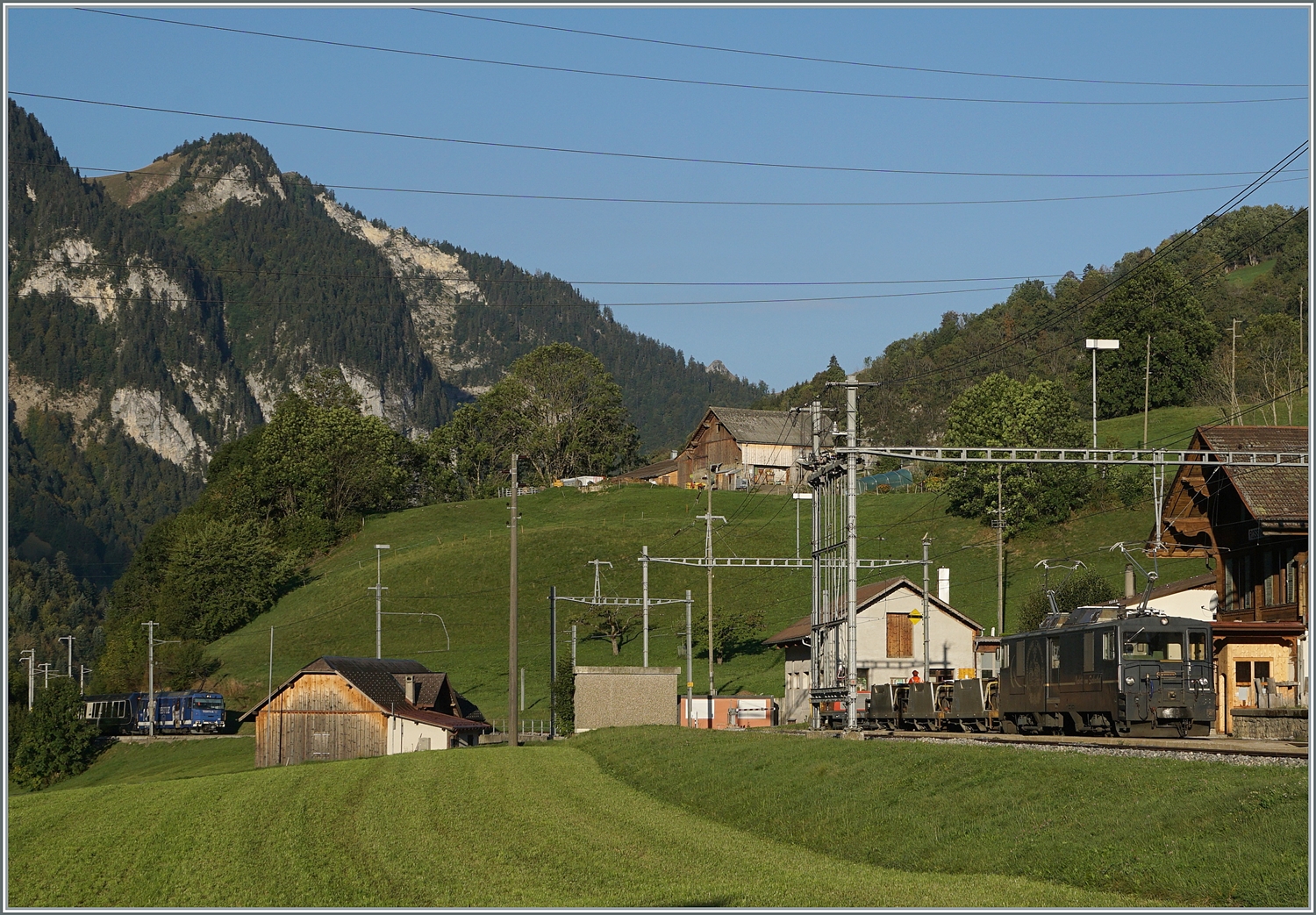 Seit die MOB GDe 4/4 nicht mehr im planmässigen Reisezugverkehr zum Einsatz kommen, sind Bilder dieser Loks nicht mehr so einfach zu bekommen. Um so mehr freute ich mich,  als ich  die GDe 4/4 6002 in Rossinière mit einem kurzen Güterzug entdeckte. Die Lok schob die Wagen und war in Richtung Montreux unterwegs. Der Grund des gut viertelsündigen Aufenthaltes ist ganz links im Bild wage zu erkennen: Der Güterzug musste die Kreuzung mit dem von der MOB Ge 4/4 8001 geführten Goldenpass Express GPX 4064, unterwegs von Montreux nach Interlaken Ost, abwarten. 

29. September 2023