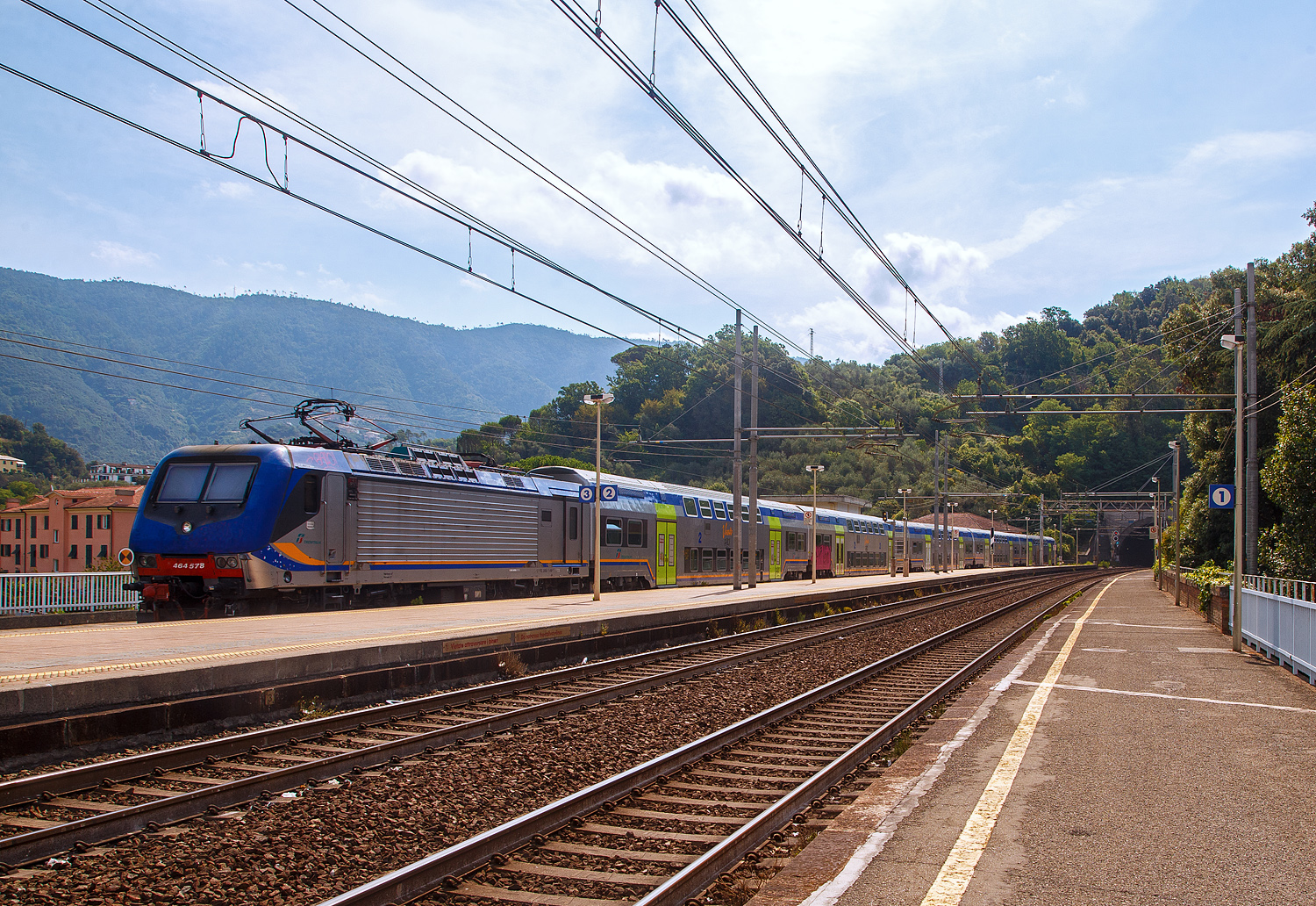 Steuerwagen voraus verlässt ein Trenitalia „Vivalto“- Doppelstock-Wendezug, geschoben von der Trenitalia E.464 578 (eine Bombardier TRAXX P160 DCP), als Cinque Terre Express nach La Spezia, am 23.07.2022 den Bahnhof Levanto an der Italienischen Riviera (nördlich der Cinque Terre) an der Bahnstrecke Pisa–Genua (RFI Strecke-Nr. 77 / KBS 31 La Spezia–Genua).