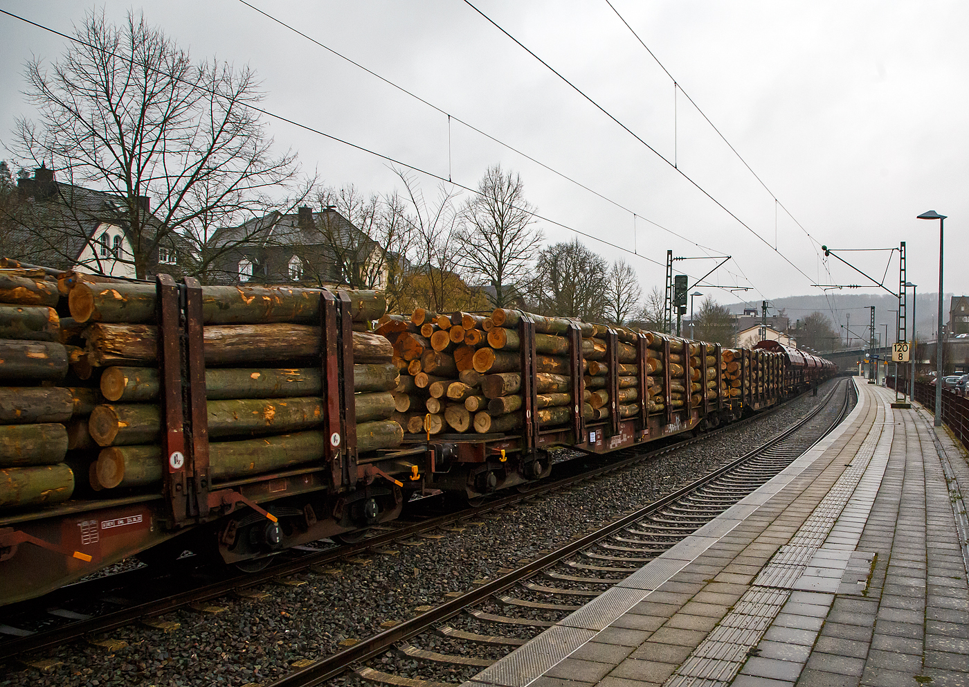 Vierachsiger Drehgestell-Flachwagen Doppelrungen und Niederbindeeinrichtung, 31 80 4723 423-2 D-DBSNI, der Gattung Snps 719 der DB Cargo Logistics GmbH (ex DB Schenker Nieten GmbH), beladen mit Buchen-Rundholz am 31.01.2023 im Zugverband bei der Durchfahrt in Kirchen (Sieg).

Diese Drehgestell-Flachwagen wurde speziell für den Transport von Rohren, Profilstahl, Flachstahlprodukten, sowie Stamm- und Schnittholz entwickelt und zeichnet sich durch hohe Ladekapazität und optimierte Ladesicherung aus. Sie wurden ab 1980 als Sps 719 beschafft und ab 1988 in Snps 719 umgezeichnet.

Zur Aufnahme und Abstützung der Ladung sind auf dem Wagenboden Ladeschwellen und an den Wagenlängsseiten Rungen angebracht. Zur Verzurrung der Ladung sind von Hand zu bedienende Niederbindeeinrichtungen vorhanden. Für die Auflage des Ladegutes sind hölzerne Ladeschwellen im Rungenbereich und im Abstand von 1 m von Wagenende vorhanden. Außerdem sind feste 5 mm niedrigere Hilfsladeschwellen zwischen den Rungen zur Unterstützung von leicht durchhängendem Ladegut (z. B. Schnittholz) angeordnet. Die Ladeschwellen sind genügend hoch, so dass die handelsüblichen Umschlagmittel verwendet werden können. Der Wagenboden ist mit einem begehbaren Loch- bzw. Riffelblech vollständig abgedeckt. Zur Aufnahme von Lasten oder zum Befahren mit Flurförderfahrzeugen sind die Abdeckungen nicht geeignet. Zur Sicherung der Ladung sind auf jeder Wagenlängsseite in gleichmäßigen Abständen 8 Rungen vorhanden. Die Rungen sind mit dem Untergestell-Außenlangträger fest verbunden und so ausgeführt, dass sie die durch die Ladung entstehenden Kräfte in Wagenlängs- und Wagenquerrichtung sicher aufnehmen können. Die Innenseiten der Rungen sind ausgekleidet.

Zur Verzurrung des Ladegutes ist jedes Rungenpaar mit einer Niederbindeeinrichtung ausgerüstet, die von einer Person bedient werden kann. Die Spanngurte sind zur Schonung des Ladegutes mit einem elastischen Werkstoff ummantelt. Die Länge des Gurtes und die Teilung der Raster sind so gewählt, dass auch Ladungen, die nur etwa die halbe Rungenhöhe einnehmen, verzurrt werden können.

TECHNISCHE DATEN:
Gattung: Snps 719
Spurweite: 1.435 mm (Normalspur)
Länge über Puffer: 20.840 mm
Drehzapfenabstand: 15.800 mm
Radsatzstand in den Drehgestellen: 1.800 mm
Ladelänge: 19.000 mm
Ladebreite: 2.723 mm (zwischen den Rungen)
Fußbodenhöhe über SO: 1.280 mm (OK Ladeschwelle)
Rungenhöhe: 2.000 mm
Eigengewicht: 24.400 kg
Zuladung bei Lastgrenze S: 63 t (ab Streckenklasse D)
Max. Geschwindigkeit: 100 km/h / 120 km/h (leer)
Kleinster Gleisbogenhalbmesser: 35 m
Bauart der Bremse: KE-GP (LL)
Bremssohle: IP 116
Verwendungsfähigkeit: RIV