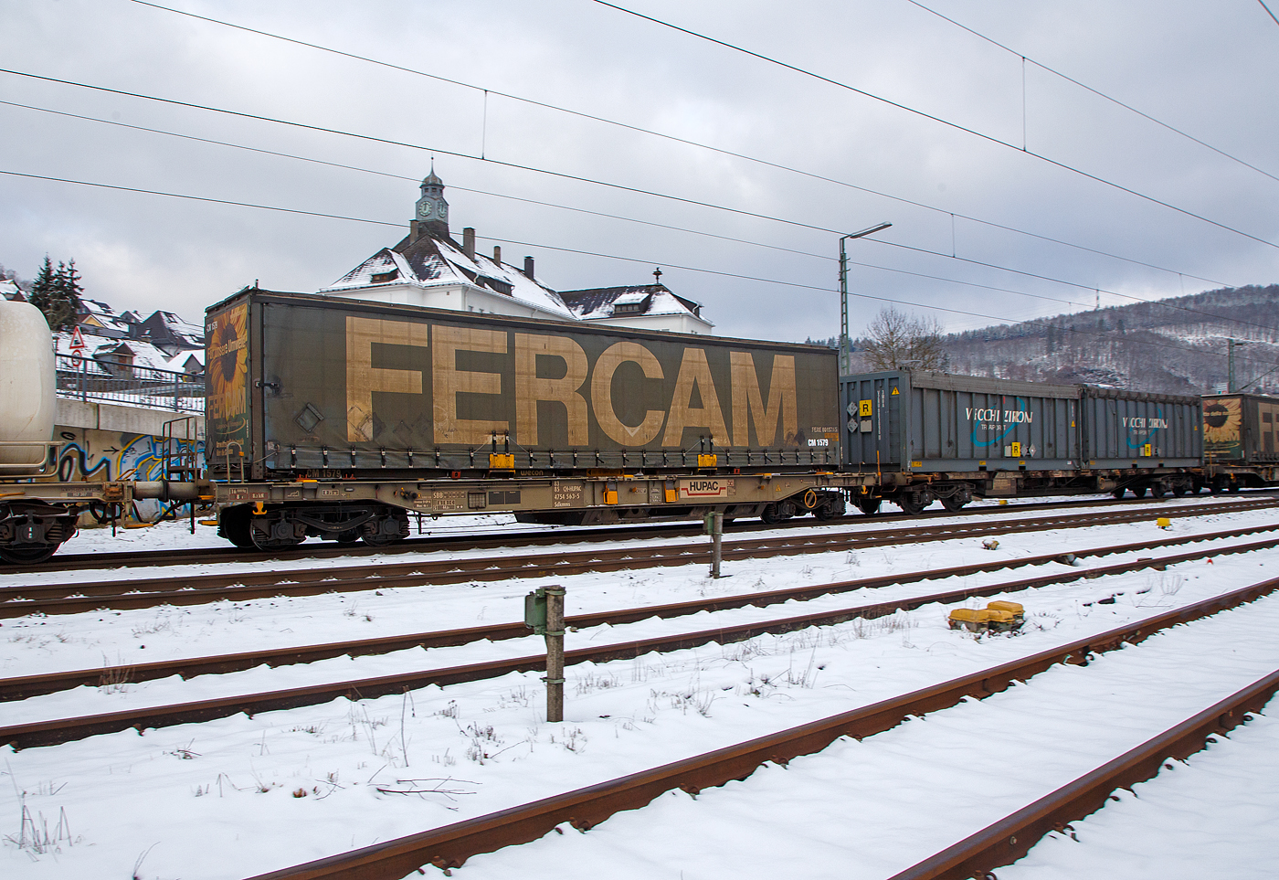 Vierachsiger Drehgestell-Taschenwagen für den Transport von Sattelaufliegern und Container 83 85 4754 563-5 CH-HUPAC der Gattung Sdkmms der HUPAC Intermodal SA, im Zugverband am 21.01.2023 bei der Zugdurchfahrt in Niederschelden (Sieg), hier beladen mit einer Sattelauflieger-Wechselbrücke. 

Der Wagen wurden 1980 von Waggonfabrik Talbot in Aachen gebaut.

TECHNISCHE DATEN:
Spurweite: 1.435 mm
Länge über Puffer: 16.440 mm
Drehzapfenabstand: 11.200 mm
Achsabstand im Drehgestellen: 1.800 mm
Max Ladelänge: 1 Sattelanhänger  (14.400 mm f. Container und Wechselbehälter)
Eigengewicht: ca. 16.000 kg 
Max. Zuladung bei Lastgrenze S: 44,0  t (ab Streckenklasse A)
Höchstgeschwindigkeit: 100 km/h (beladen) / 120 km/h (leer)
Bremse: O-GP-A (K)
Bremssohle: Jurid 816M (K-Sohle)
Kleinster befahrbarer Gleisbogen: R 75 m
Intern. Verwendungsfähigkeit: Privatwagen

Die Bedeutung der Gattungs- und Kennbuchstaben (hier Sdkmms):
S - Drehgestell-Flachwagen in Sonderbauart
d - für den Transport von Straßenfahrzeugen eingerichtet
k - mit vier Radsätzen höchste Lastgrenze unter 40 t
mm - mit vier Radsätzen Ladelänge unter 15 m
s - Höchstgeschwindigkeit 100 km/h (beladen)