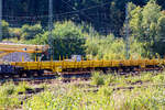 Vierachsiger Drehgestellflachwagen mit klappbaren Seitenborden und Rungen, der Hering Bahnbau GmbH (Burbach), 80 80 3948 001-3 D-HGUI, Gattung Res, als Schutzwagen zum GOTTWALD Gleisbauschienenkran GS