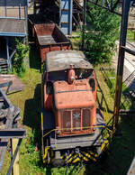 Die ex D V der AG der Dillinger Hüttenwerke (Normalspur – Diesellokomotive 5 /Henschel 29726), eine C-gekuppelte Henschel DH 440 Ca, hier am 01 Juli 2025 als Denkmal ausgestellt im Bereich der Kokssieberei der Völklinger Hütte. 

Die dreifachgekuppelte Lok vom Typ Henschel DH 440 Ca wurde 1959 von der Henschel-Werke GmbH in Kassel unter der Fabriknummer 29726 gebaut und als D V an die AG der Dillinger Hüttenwerke geliefert, wo sie bis 2000 im Dienst war. Die AG der Dillinger Hüttenwerke schenkte 2003 diese Lok dem Weltkulturerbe Völklinger Hütte, heutiger Eigentümer ist die Initiative Völklinger Hütte e.V., diese Lok war nie in Völklingen im Einsatz, aber ähnliche Lokomotiven dieser Bauart werden heute noch im Werksverkehr in Völklingen eingesetzt. Mit solchen Zügen wurden unter anderem Koks zur Kokssieberei transportiert, oder auch Schrottpakete zum Verladen in die Hängebahnwagen. Bei der AG der Dillinger Hüttenwerke sind baugleiche Loks im Werksverkehr in Dillingen im Einsatz. 

Übrigens die AG der Dillinger Hüttenwerke ist heute der einzige Produktionsstandort von Roheisen im Saarland und sie ist das größte Grobblechwerk Europas. Auch wenn die Saarstahl AG mit Anteilseigner ist, so darf man diese gleichsetzen. 

Zu den Loks:
Die Henschel DH 440 Ca sind C-gekuppelte standardisierte Werksbahn-Dieselloks der 3. Generation von Henschel mit dieselhydraulischem Antrieb mittels Kuppelstangen. Die 28 Lok von diesem Typ, mit einem mittelschnell laufenden MAN-Motor, wurden zwischen 1957 und 1965 gebaut. Allein 6 Exemplare wurden an die AG der Dillinger Hüttenwerke geliefert (D V bis D X).

Anders als die DH 440 der 2. Generation hat die DH 440 Ca (der 3. Generation) eine außenliegende Blindwelle (daher auch der Zusatz Ca), es ist auch größte Unterschied. Wobei auch einige Konstruktive Änderungen mitbrachte. 

TECHNISCHE DATEN:
Gebaute Anzahl: 28
Spurweite: 1.435 mm (Normalspur)
Achsformel: C
Lokgewicht: ca. 43 t
Länge über Puffer: 8.900 mm
Fester Radstand: 3.000 mm
Kleinster bef. Halbmesser: 50 m
Höchstgeschwindigkeit:  30 km/h / 60 km/h
Motor: wassergekühlter 8-Zylinder 4-Takt MAN-Dieselmotor mit Aufladung vom Typ MAN W 8 V 17,5/22 A 
Hubraum: 42.320 ccm
Leistung: 324 kW (440 PS)
Nenndrehzahl: 1.100 U/min
Getriebe: Voith L 37 U
Leistungsübertragung: hydraulisch auf Blindwelle, von dieser über Kuppelstangen auf die Räder. 
