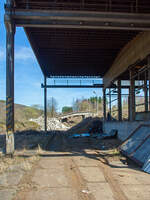 Die letzten Reste der Bremsbahn der Eiserfelder Steinwerke AG des Basaltbruches Mahlscheid (Mahlscheiderkopf). Die ehemalige Verladestation am 24.03.2011 (im gleichen Jahr angerissen) bei der alten Ziegelei in Herdorf.

Der ehemalige Steinbruch Mahlscheid (heute NSG) befindet sich im Westerwald an der Landesgrenze der Bundesländer Rheinland-Pfalz und Nordrhein-Westfalen im Bereich der Gemeinden Herdorf (Landkreis Altenkirchen) und Struthütten (Landkreis Siegen-Wittgenstein). Mitten durch den ehem. Steinbruch verläuft die Landesgrenze, so wurde der Bruch von zwei Firmen betrieben, zum einen auf der Herdorferseite (zu RLP) von der Firma Klein und zum anderen auf der Struthüttenerseite (zu NRW) von den Eiserfelder Steinwerke AG. Von beiden Brüchen führten Bremsbahnen hinab ist Tal. Die der Eiserfelder Steinwerke AG, war ca. 1,5 km lang und führte entlang der Landesgrenze nach hier hinab zur alten Ziegelei, wo das Gestein (Schotter) auf normalspurige Bahnwagen umgeladen wurde. Dafür führte vom Bahnhof Herdorf ein Anschlussgleis hinauf. 

Was ist eine Bremsbahn:
Eine Bremsbahn ist im Grunde eine Standseilbahn, aber ein sehr energiesparendes Konzept, zwei Wagen sind über ein Drahtseil verbunden, welches über eine Bremshaspel führt und kontrolliert abgebremst wird. Das zu fördernde Material wird mittels eines gebremsten Wagens hinabbefördert und der beladene schwererer Wagen zeiht somit den leeren Wagen wieder hinauf. Das Gewicht der zu Tal laufenden beladenen Wagen brachte einfach die dafür nötige Energie auf - also ein sehr energiesparendes Konzept.

Ob die Bremsbahn zwei parallel verlaufende Schienenstränge oder eine abtsche Weiche hatte, ist mir z.Z. nicht bekannt.
