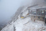 
In den Wolken .......
Eine Gondel der Wendelstein-Seilbahn erreicht am 28.12.2016 bald im Nebel bei minus 6 Grad Celsius die Bergstation am Wendelstein auf 1.724 m über NN. Der Wendelstein selbst hat eine 1.838 m.

Während man hier oben bereits bei Frost in den Wolken war, so war es im Tal warm und klar. 

Die Bergstation der Wendelstein-Seilbahn befindet 1.724 m über NN, die Talstation auf 792 m in Bayrischzell-Osterhofen.

Die Wendelstein-Seilbahn ist eine Großkabinenseilbahn und nach der wesentlich älteren Wendelstein-Zahnradbahn die zweite Bergbahn am Wendelstein. Die 2.953 m lange Pendelbahn wurde von Pohlig-Heckel-Bleichert (PHB) innerhalb von 18 Monaten gebaut und 1970 in Betrieb genommen. Sie erschließt den Berg von Bayrischzell-Osterhofen aus über die Südwest-Seite.

Die Wendelstein-Seilbahn, deren Kabinen aus der Herstellung des österreichischen Herstellers Carvatech (vormals Swoboda) stammen und maximal 50 Personen fassen, besitzt ein Tragseil mit 50 mm und ein Zugseil mit 30 mm Durchmesser. Der Antrieb erfolgt mit einem Motor von maximal 490 PS. Sie hat eine Höchstgeschwindigkeit von 36 km/h (10 m/s). In 7 Minuten überwindet sie damit einen Höhenunterschied von 932 m und erreicht eine Beförderungskapazität von bis zu 450 Personen/h. Sie verfügt nur über eine einzige Stütze mit der beachtlichen Höhe von 75 Metern.

Bei der Bildbearbeitung habe ich sehr darauf geachtet, das Bild so herüberzubringen wie wir es sahen. Mit der Automatik des Programmes könnte man es auch klar aussehen lassen.