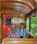 Zwei Fotografen geniessen die Fahrt in der Holzklasse des Blonay-Champy Zuges.