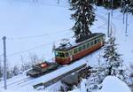 Triebwagen 23 mit seinem Güterwagen, auf dem ein Materialtransport-Behälter steht, der dann via Luftseilbahn nach Lauterbrunnen hinunter befördert wird.