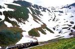 Dampfbahn Furka Bergstrecke: Lok 1 fährt unterhalb der Station Furka ins Bild hinein.