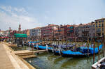 Venedig und seine Gondeln, hier am 24.07.2022 am Canal Grande nahe der bekannten Rialtobrücke (Ponte di Rialto), die man hinten links erkennen kann.